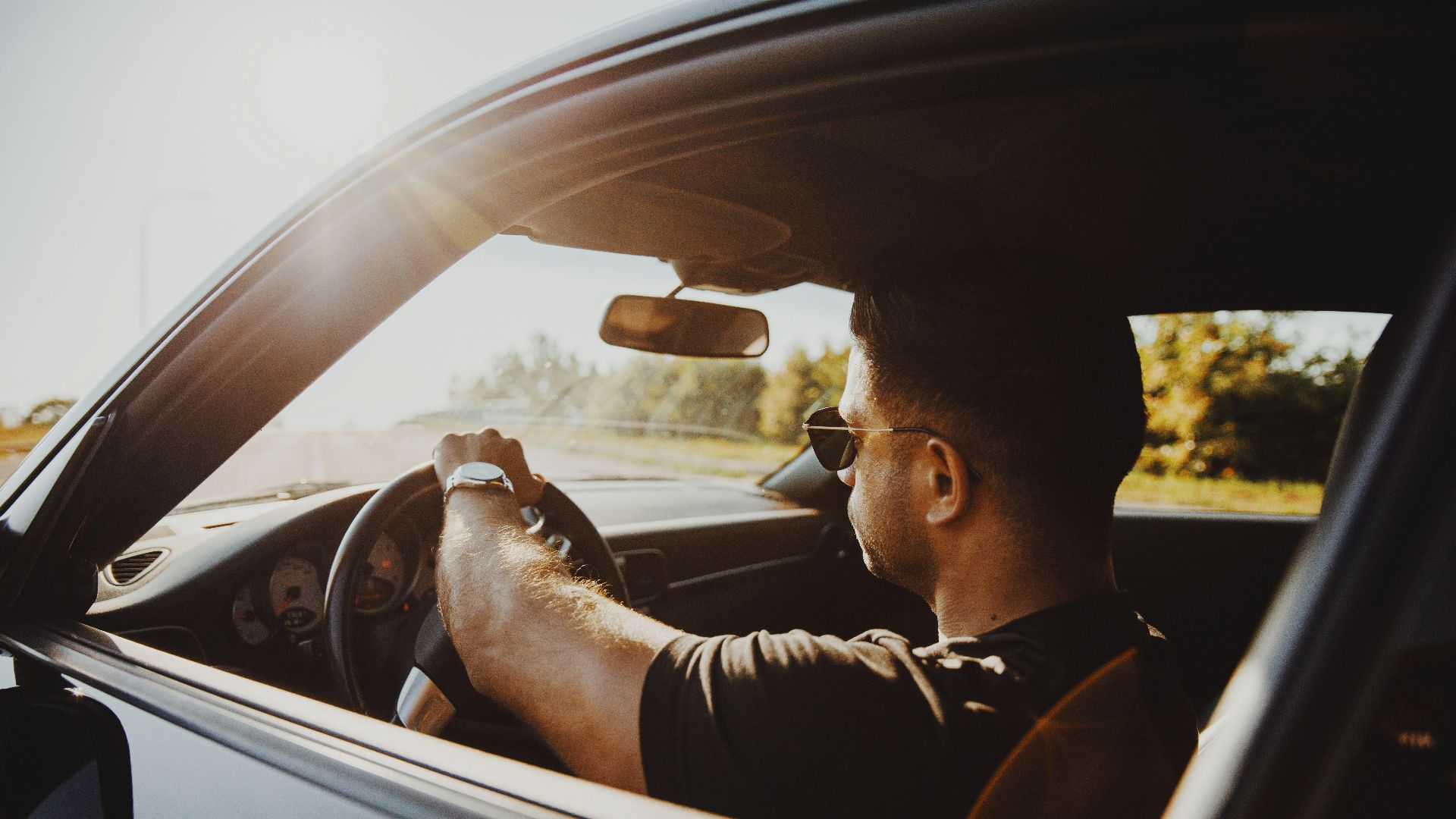 man in black jacket driving car during daytime