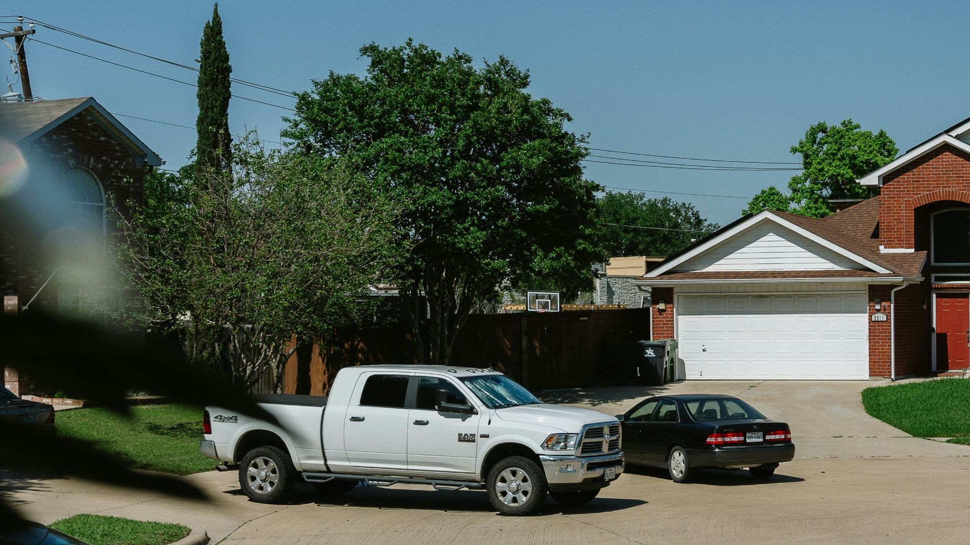 Brick house with cars in the driveway