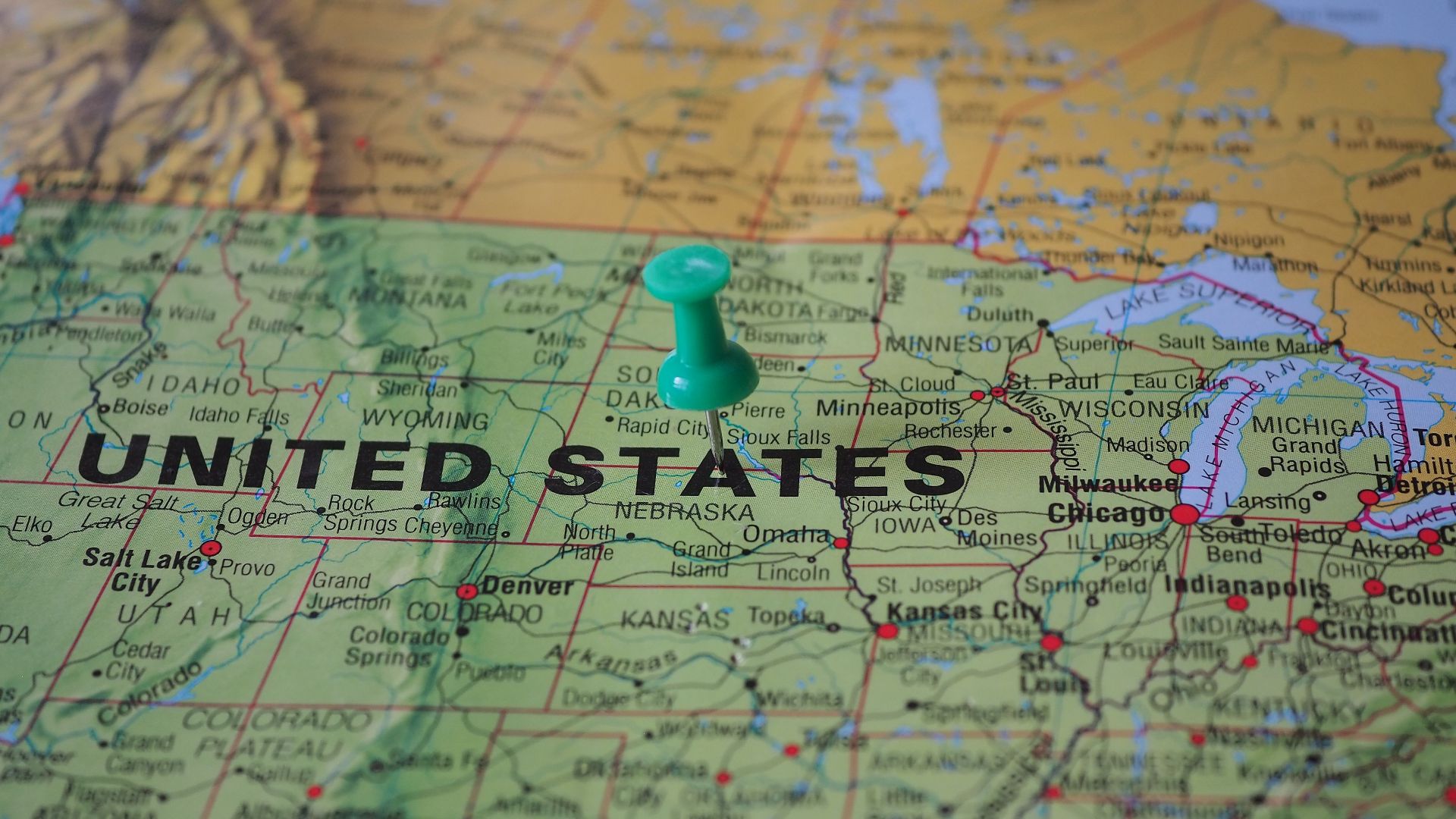 High-angle view of a map featuring the United States with a green pin indicating a specific location.
