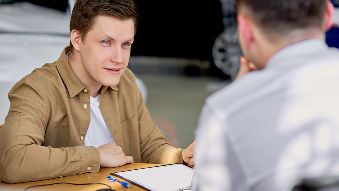 serious customer listen to salesman before signing document, making purchase in dealership