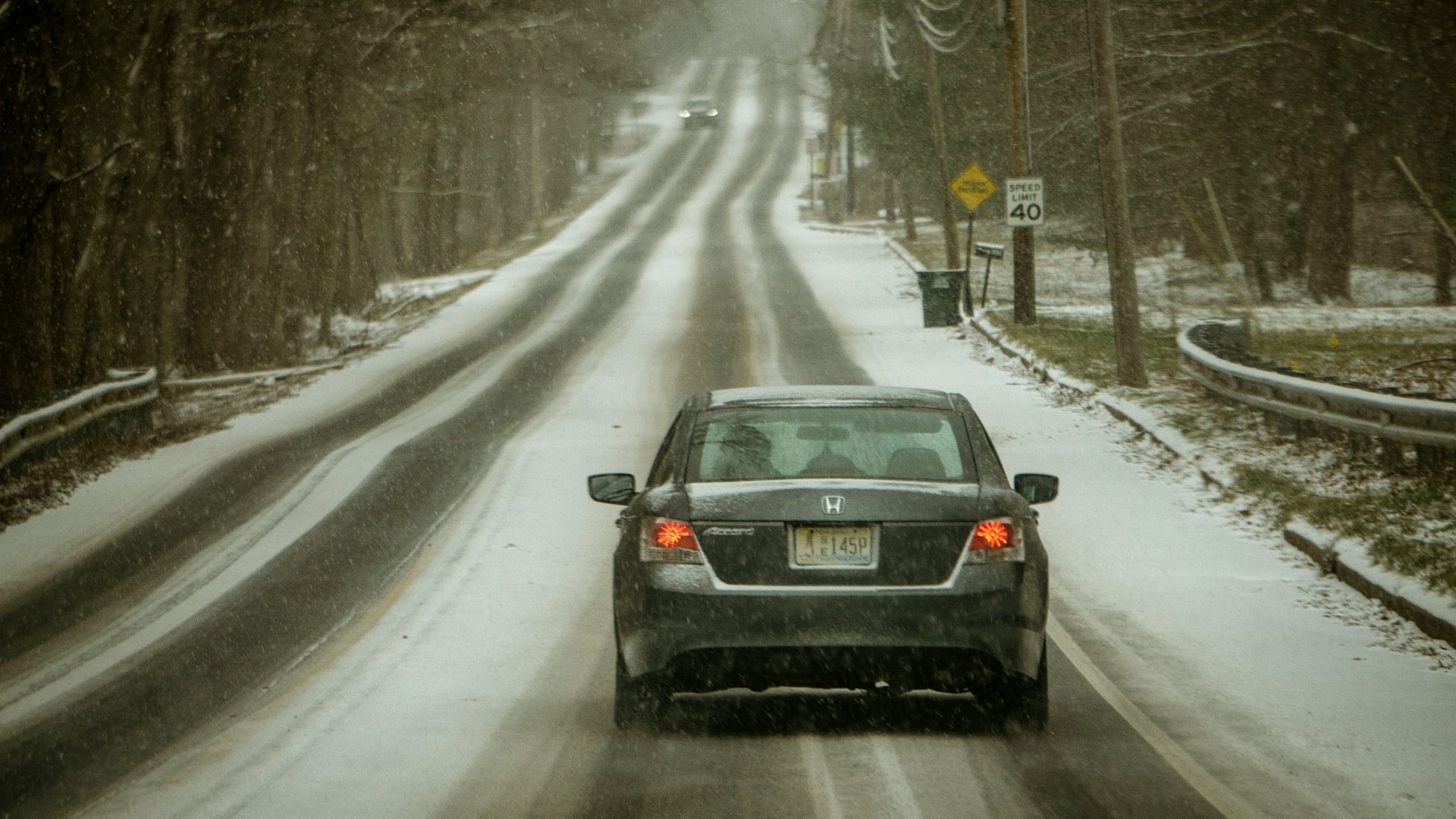 black car on road covered with snow during daytime