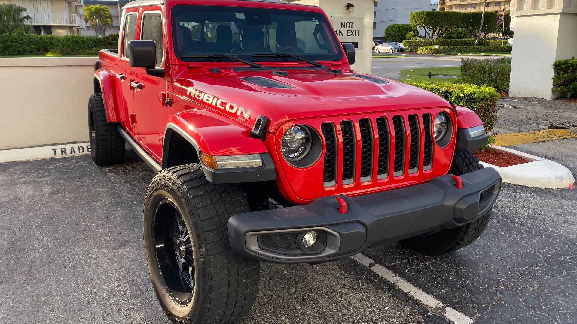 Jeep Gladiator (JT) Rubicon in red with black roof - note: aftermarket wheels - front right side view.