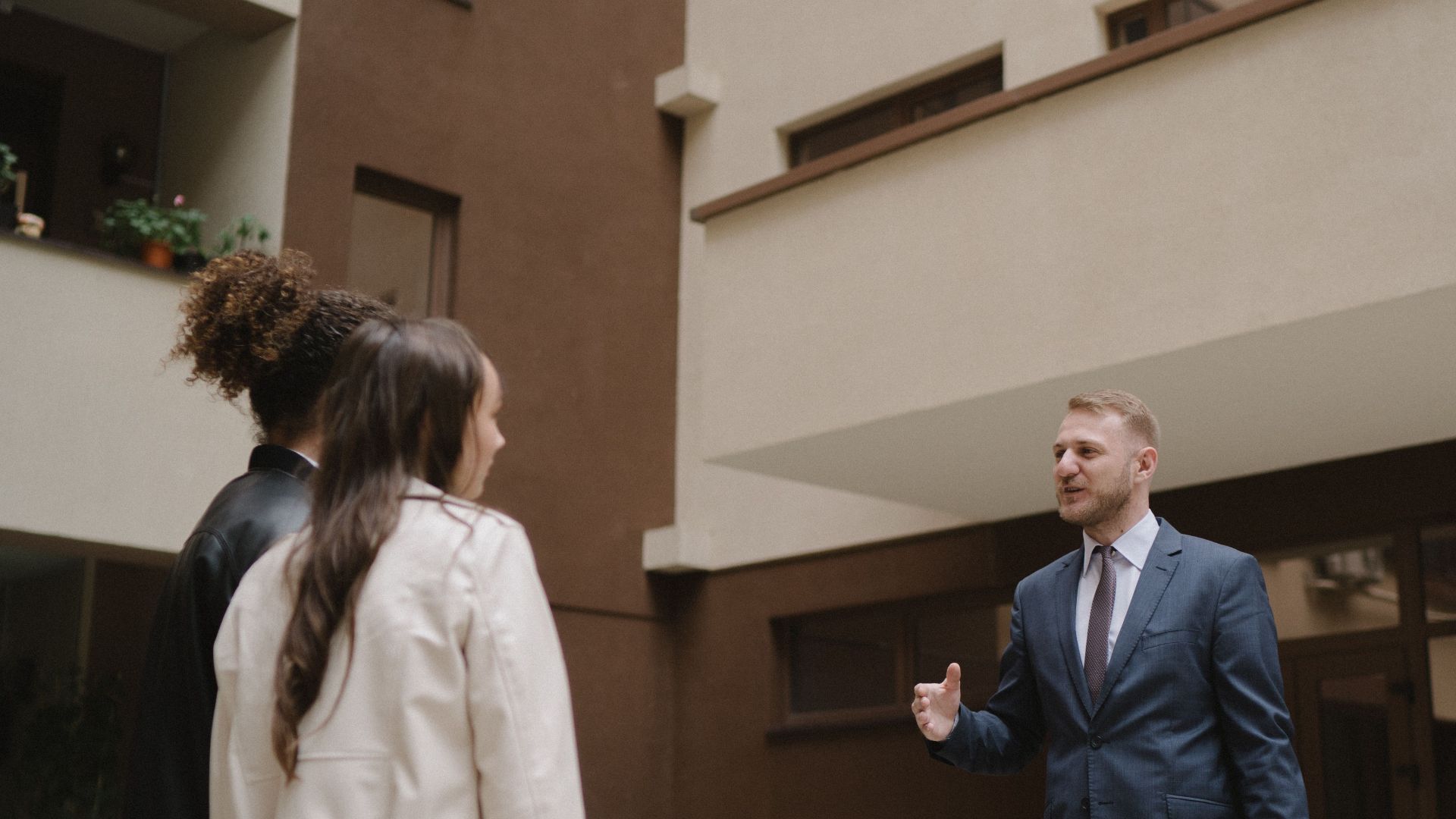 A real estate agent shows an apartment to a couple, illustrating a property tour experience.