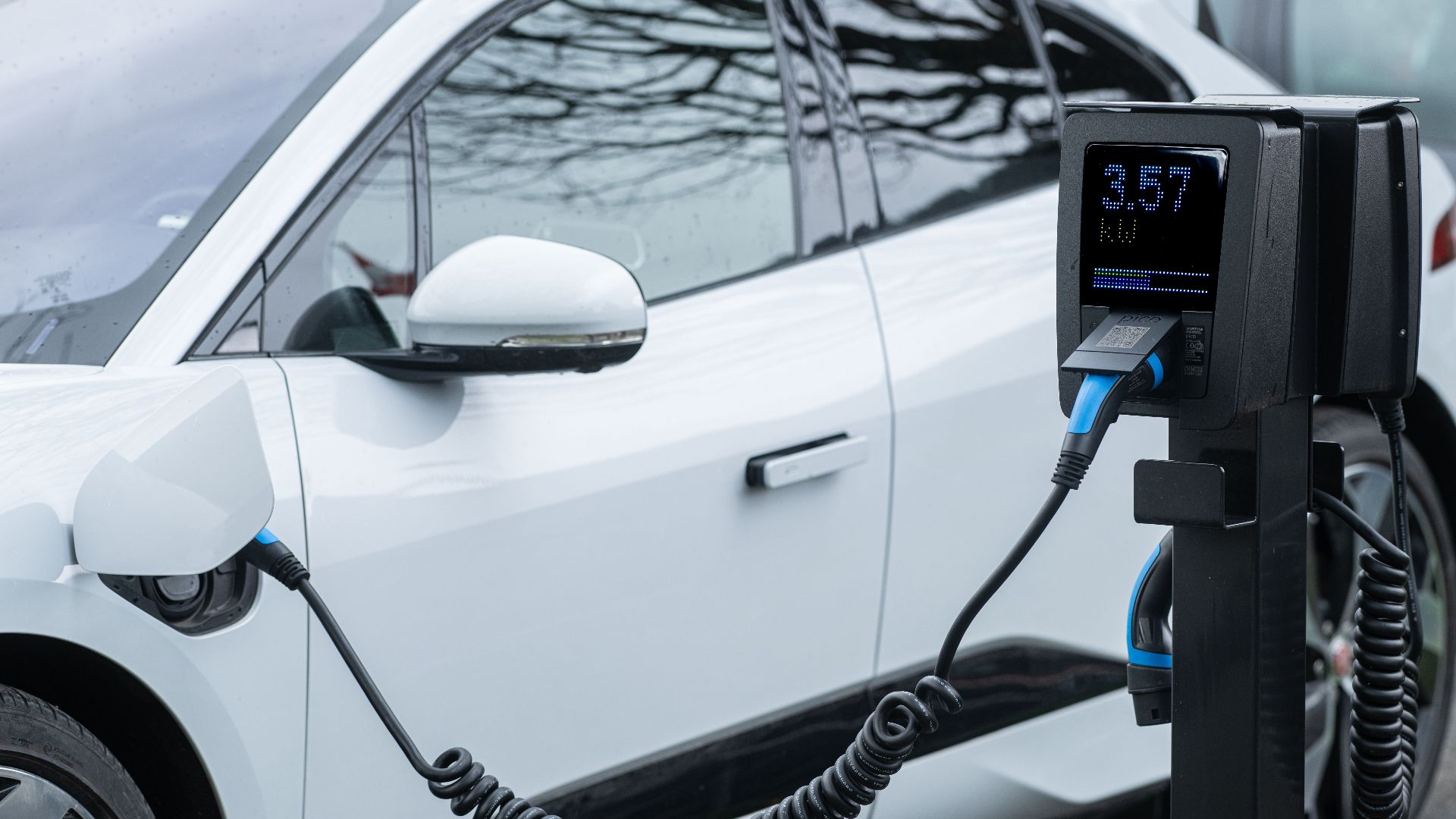 Close-up of an electric vehicle charging at a station, showcasing energy-efficient technology.