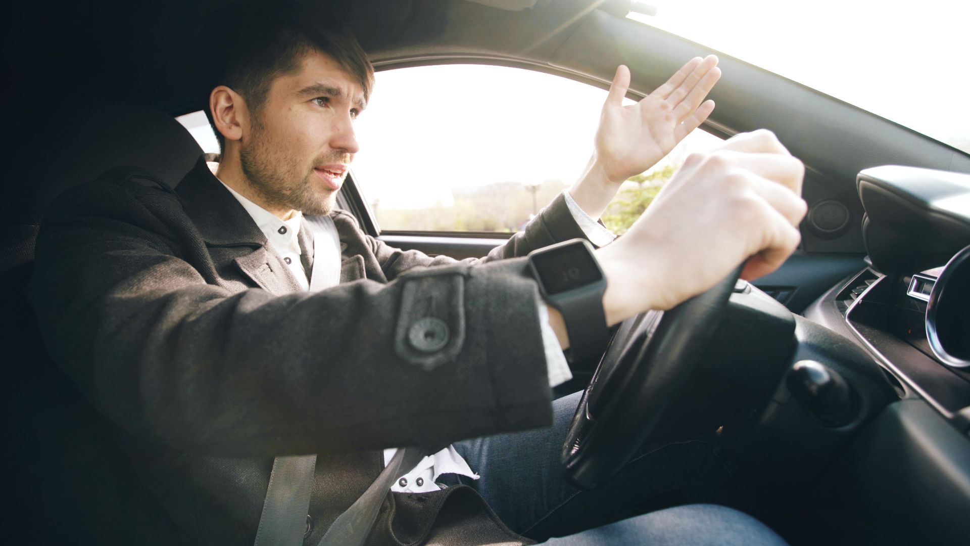 Man showing frustration while driving a car, highlighting road rage issues.
