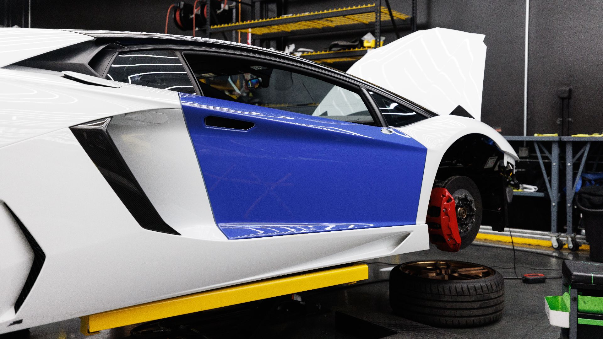 A luxury sports car being serviced inside a modern auto repair shop.