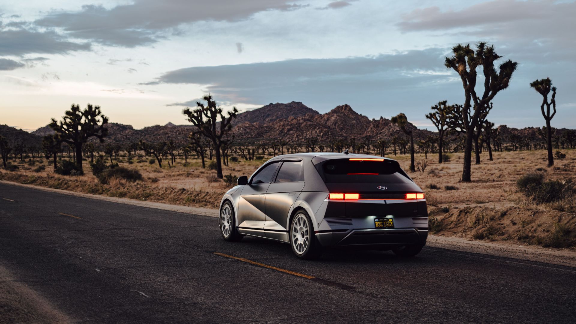 A modern electric car driving through the scenic desert roads near Joshua Tree, California.