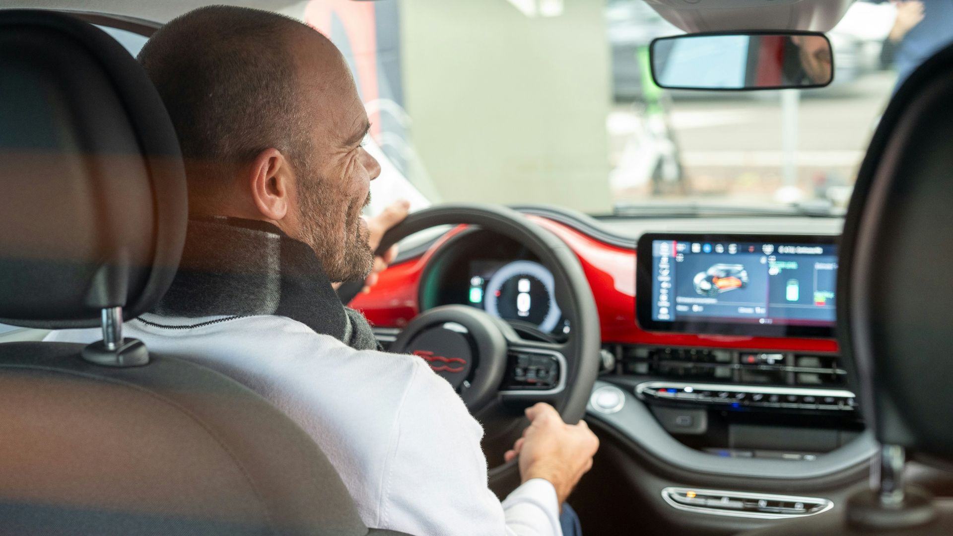 A man driving a car with a steering wheel
