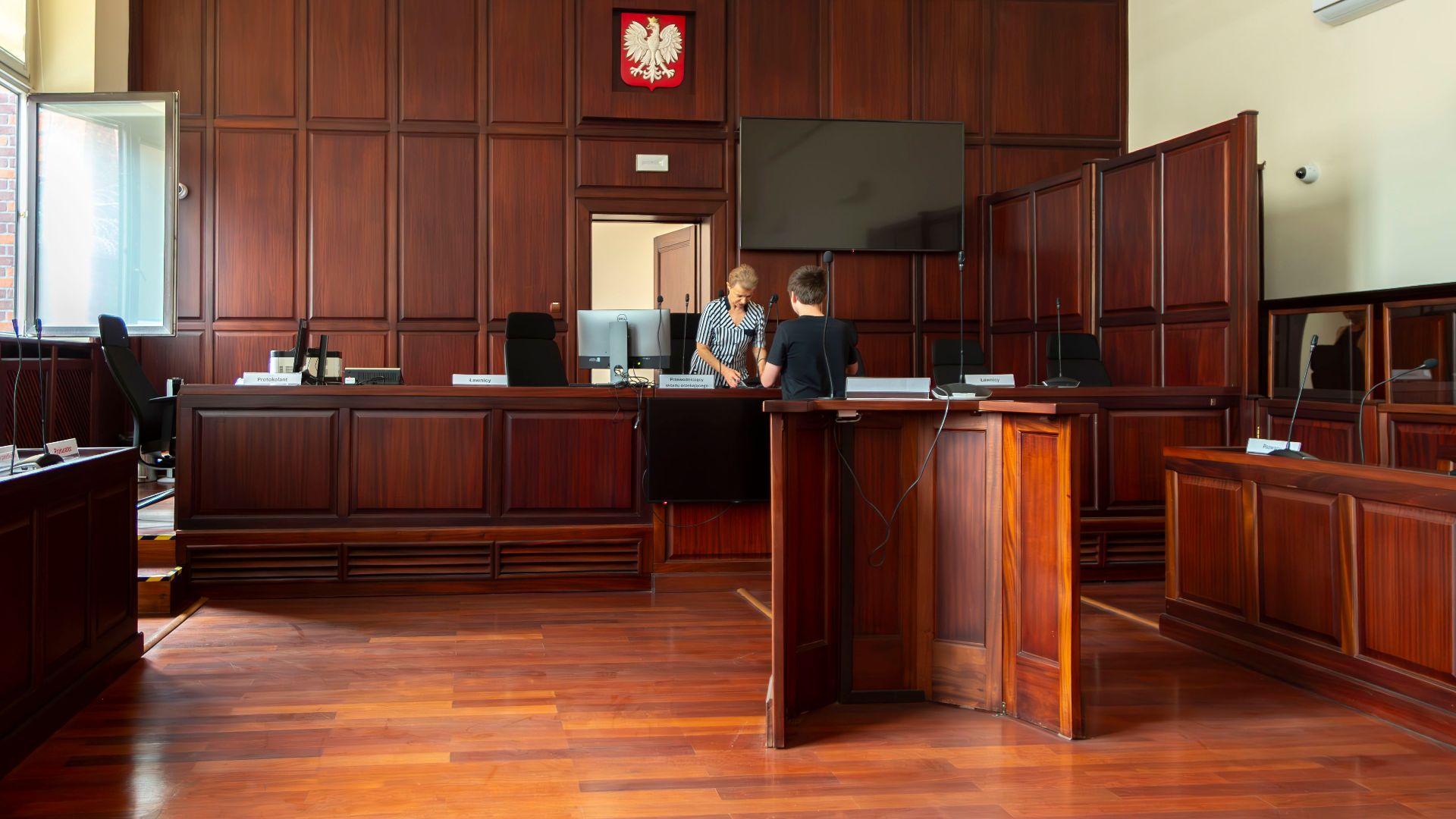 Spacious Polish courtroom with wooden panels and furniture located in Wrocław, Lower Silesia.