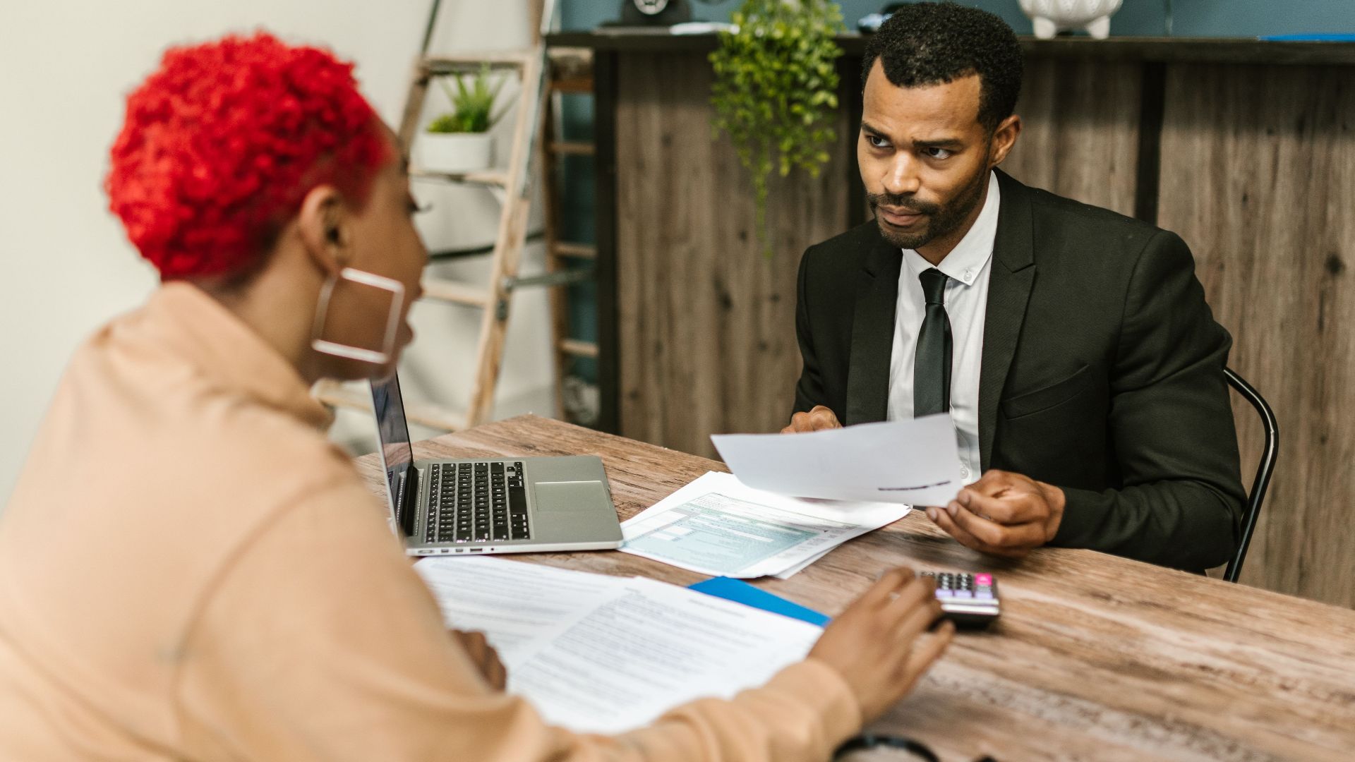 A discussion between two professionals focusing on financial documents in a modern office setting.