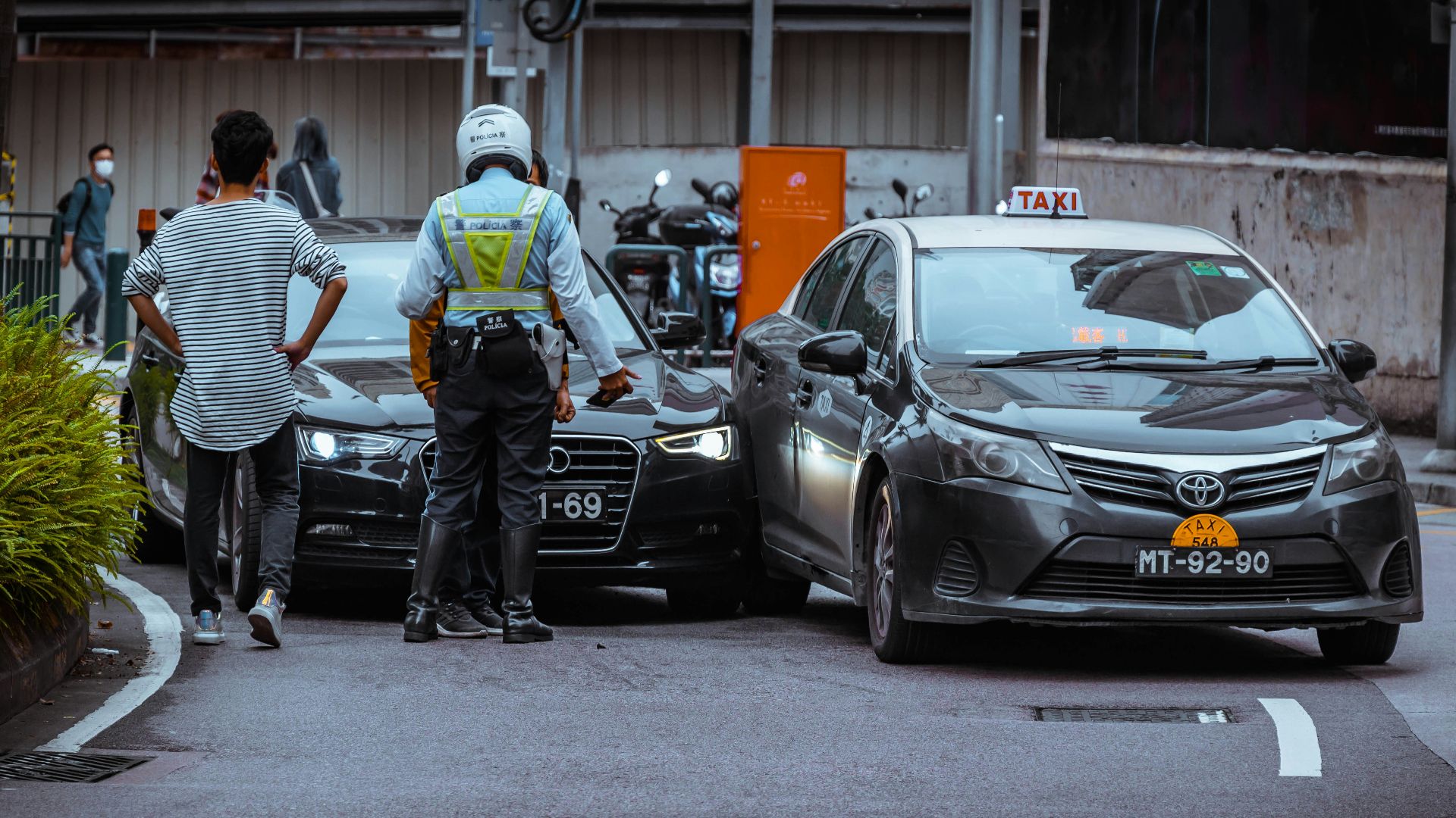 man in white and black stripe shirt and black pants standing beside black car during daytime