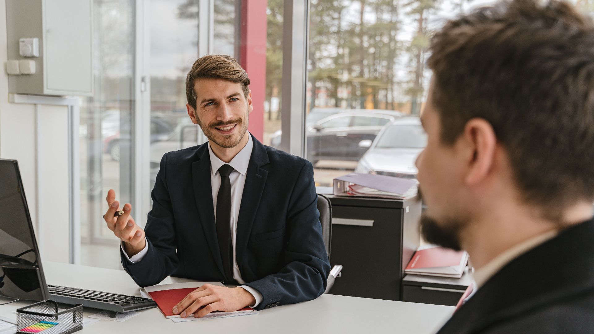 Two businessmen having a conversation in a modern office setting.