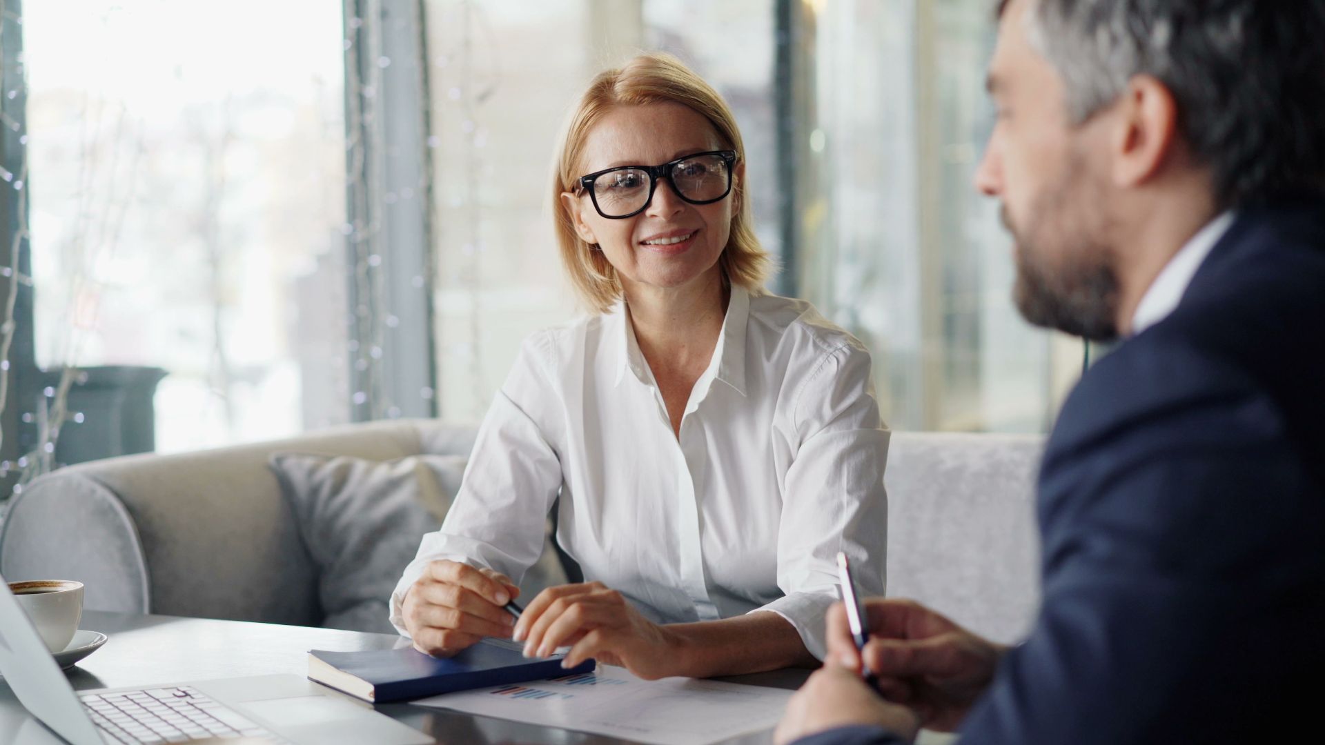 Confident businesspeople discussing strategies in a modern office setting.