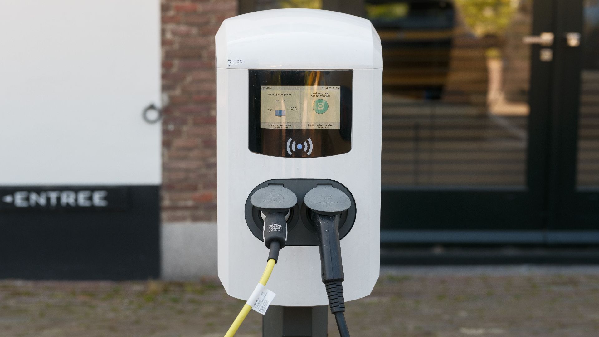 Outdoor electric vehicle charging station with connected cables.