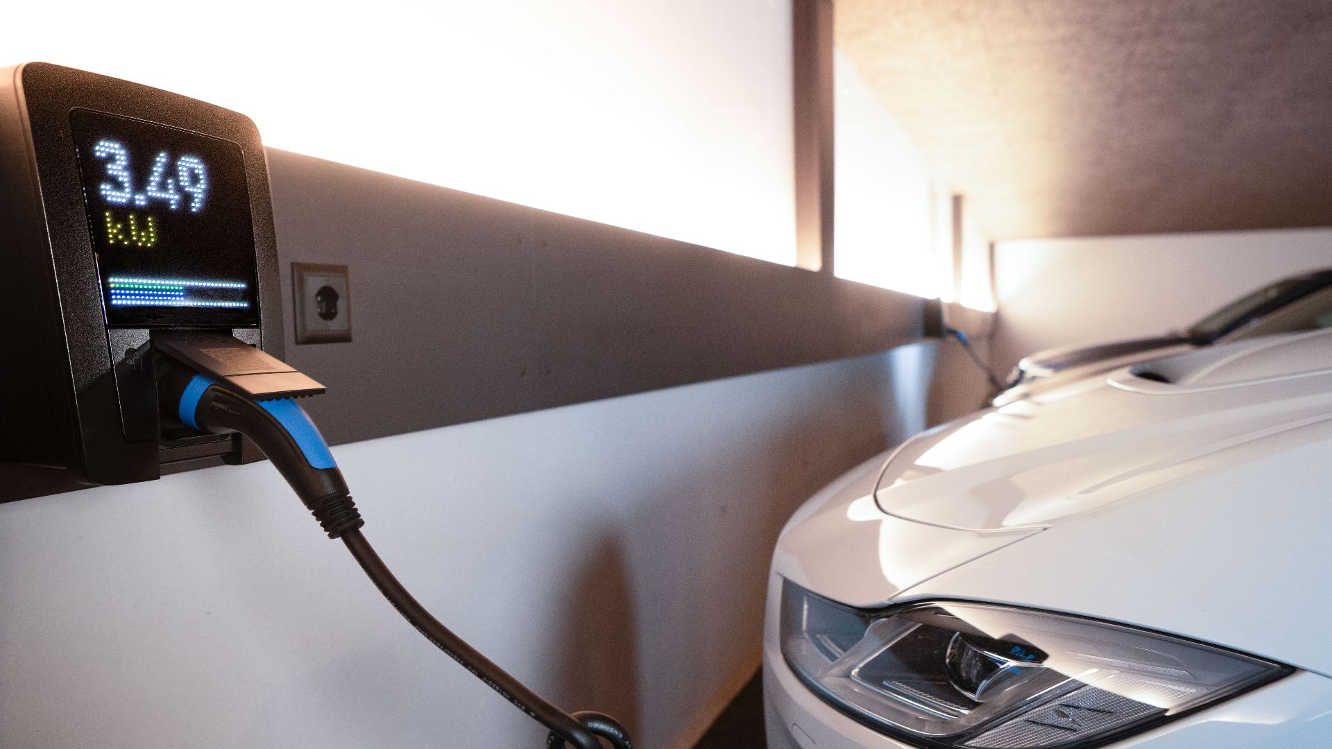 White electric car charging at indoor station, emphasizing sustainability and efficiency.