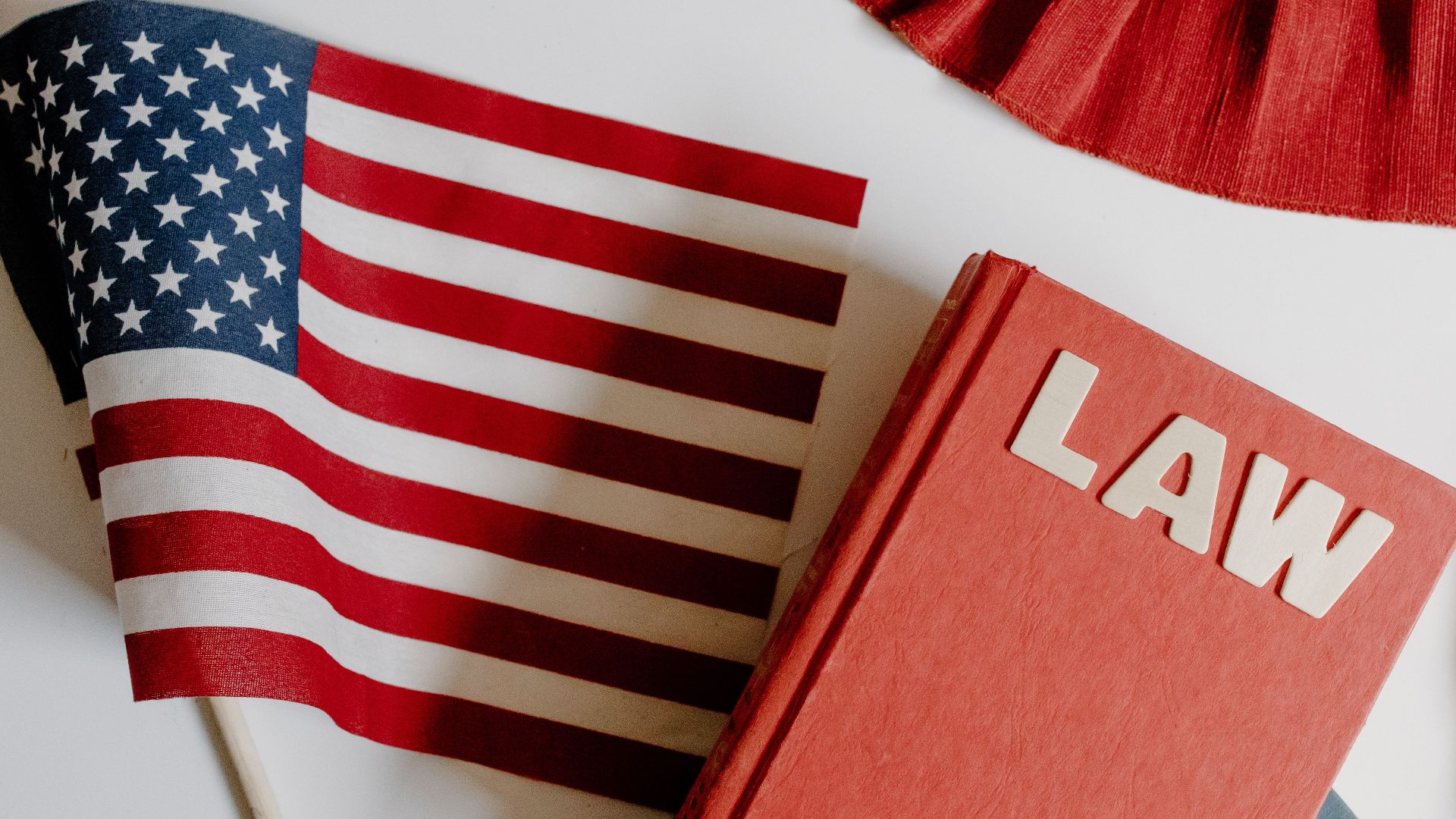 Patriotic scene with American flag and law book on a white background, symbolizing freedom and democracy.