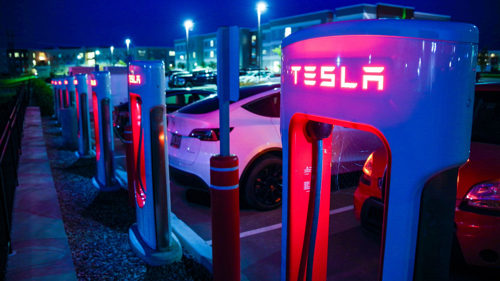 a row of tesla charging stations at night