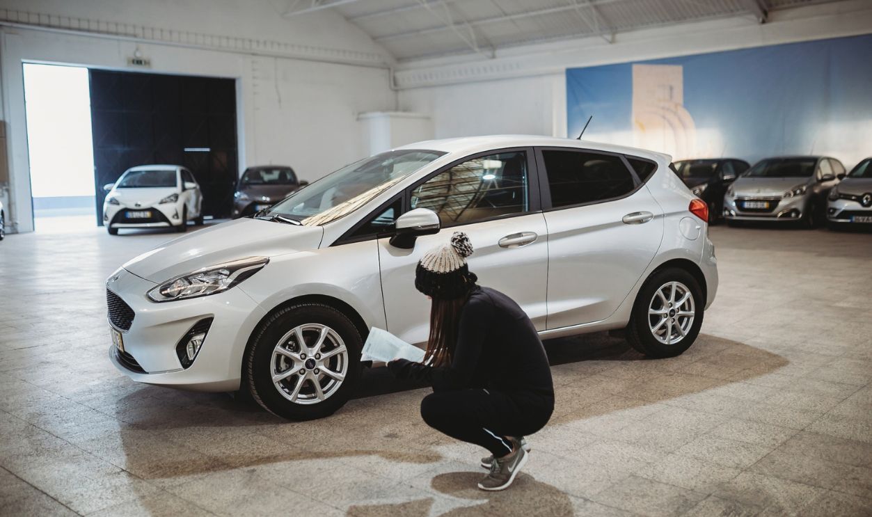 Lisbon, Portugal. January 12th 2019. Young woman checking rental car in warehouse.