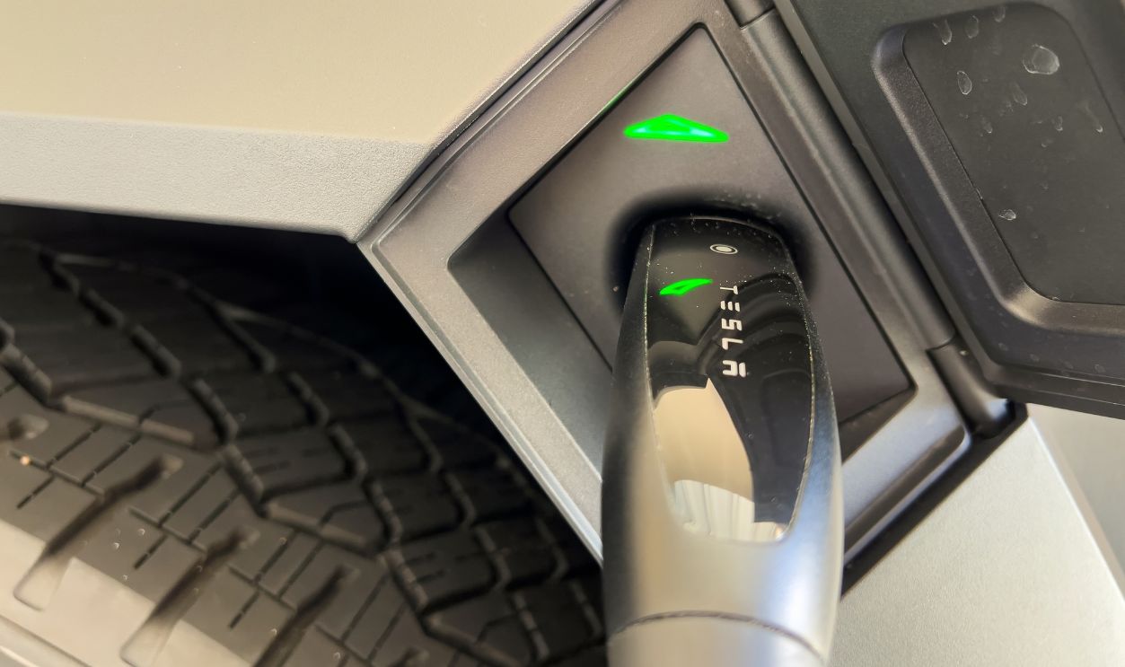 Denver, Colorado, USA-March 28, 2024-close-up view of a Tesla Cybertruck being charged, with the connector firmly plugged in, as indicated by the illuminated green lights, in a private suburban house