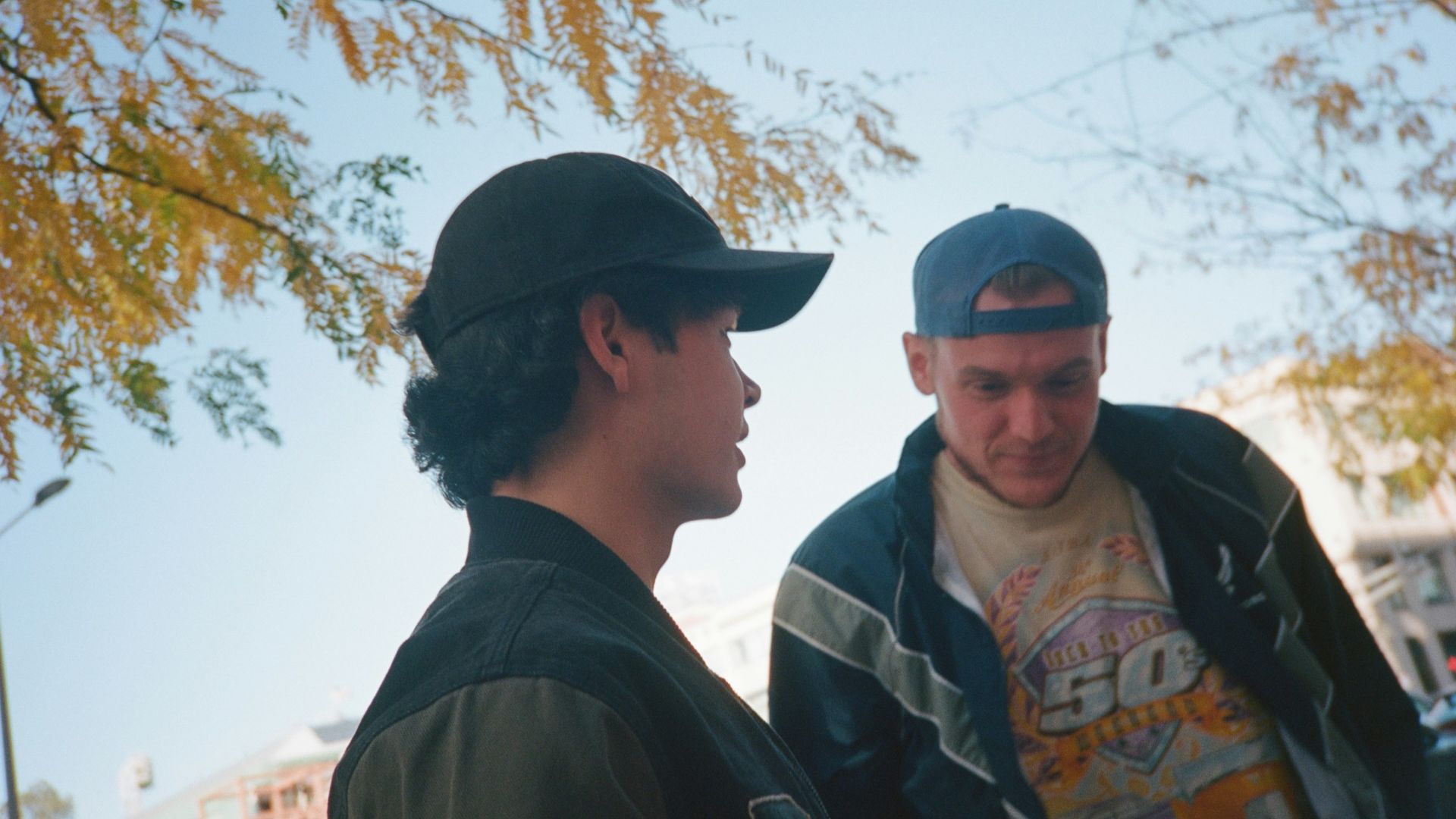 Two men standing next to each other on a street