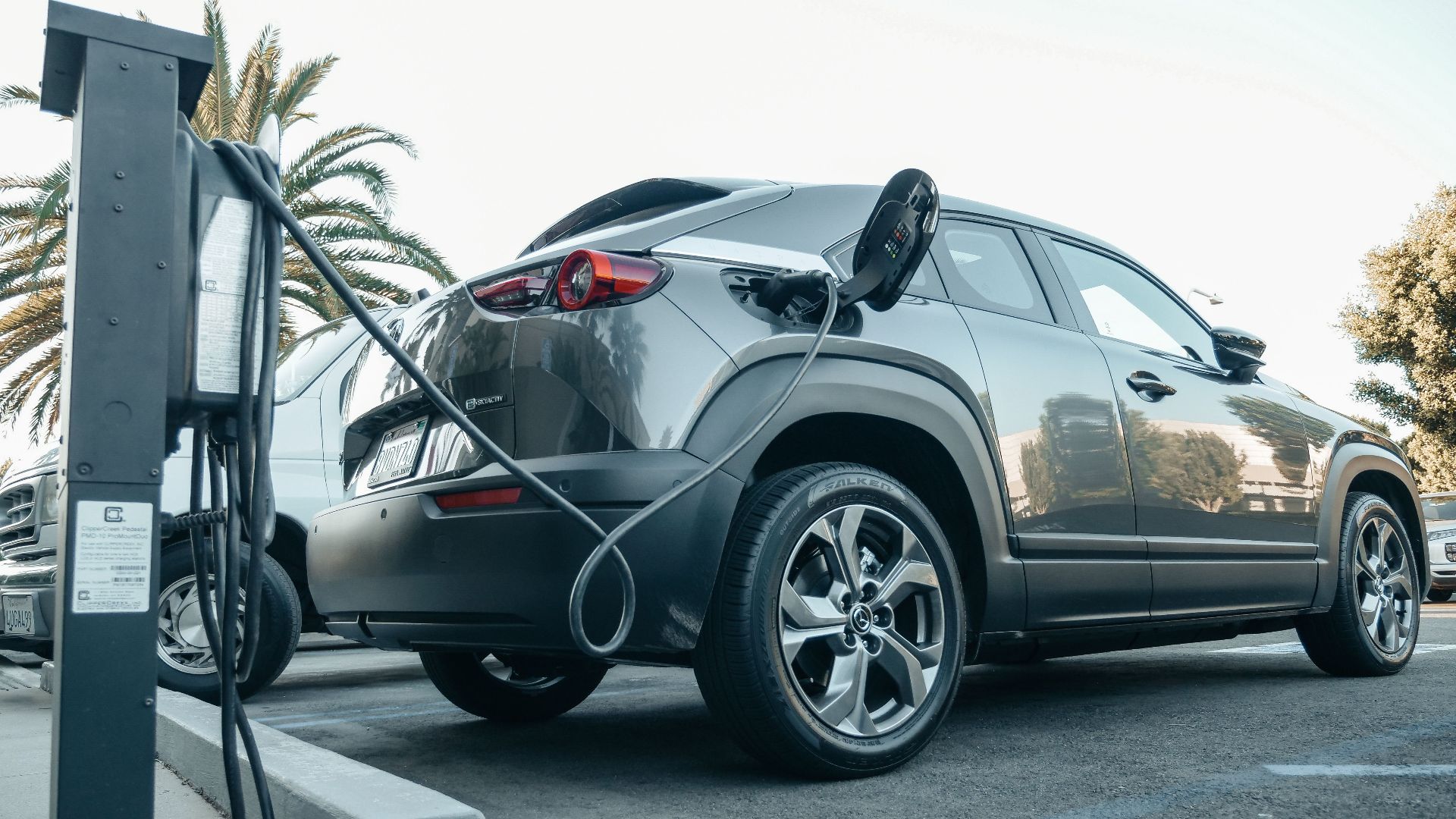 Modern electric vehicle charging at an outdoor station in daylight.