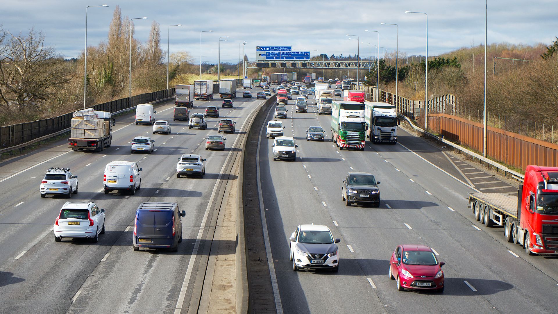 View of cars and trucks on a busy highway in St Albans, UK during daytime.