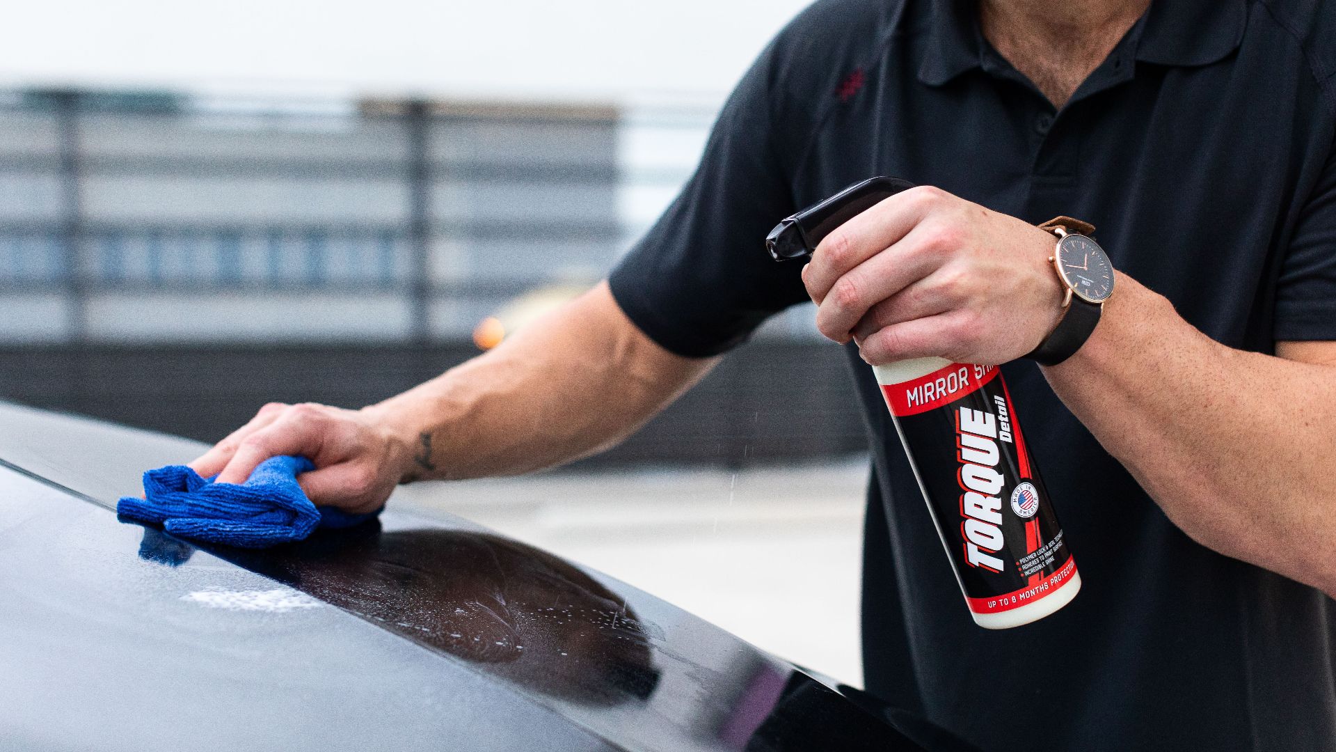 Man cleaning car with spray and cloth for shiny finish. Perfect for auto maintenance themes.