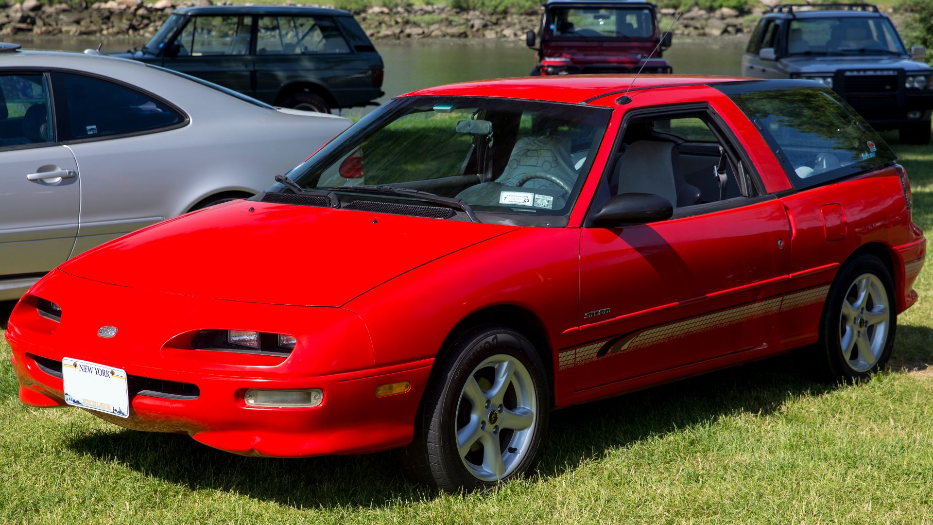1991 Geo Storm Wagonback (hatchback) in Red, displayed as part of the Radwood event which made up part of the 2022 Greenwich Concours d'Elegance. 3-speed automatic isn't the most exciting transmission, the cheapo alloys and the stickers also don't do it a