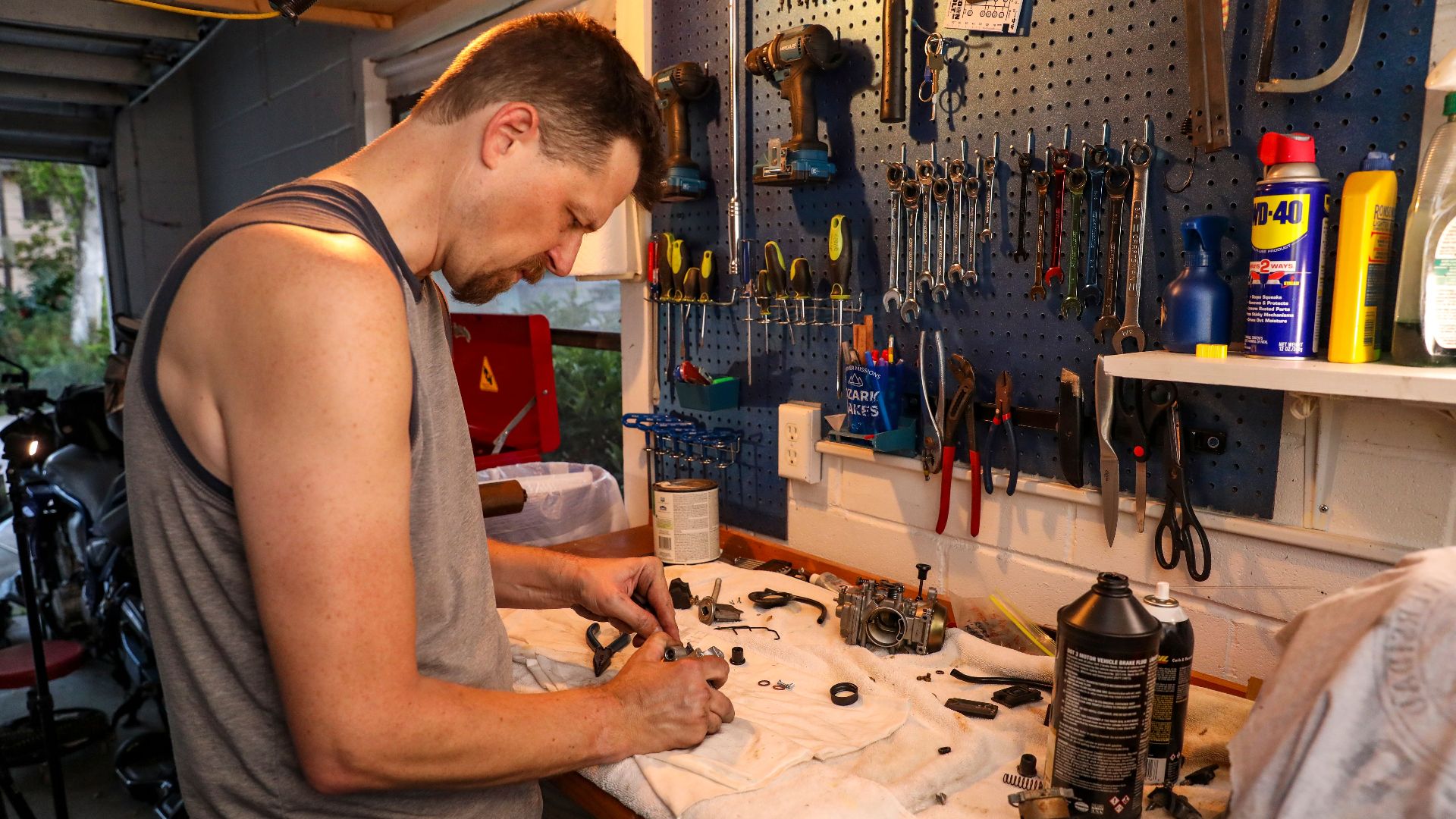A mechanic working on engine parts in a well-organized garage in Orlando, Florida.