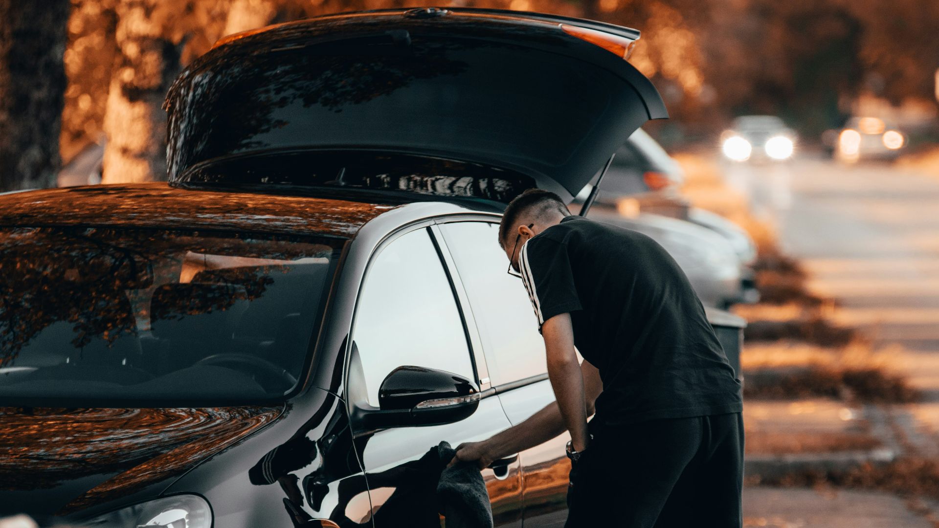 a man working on a car on the side of the road