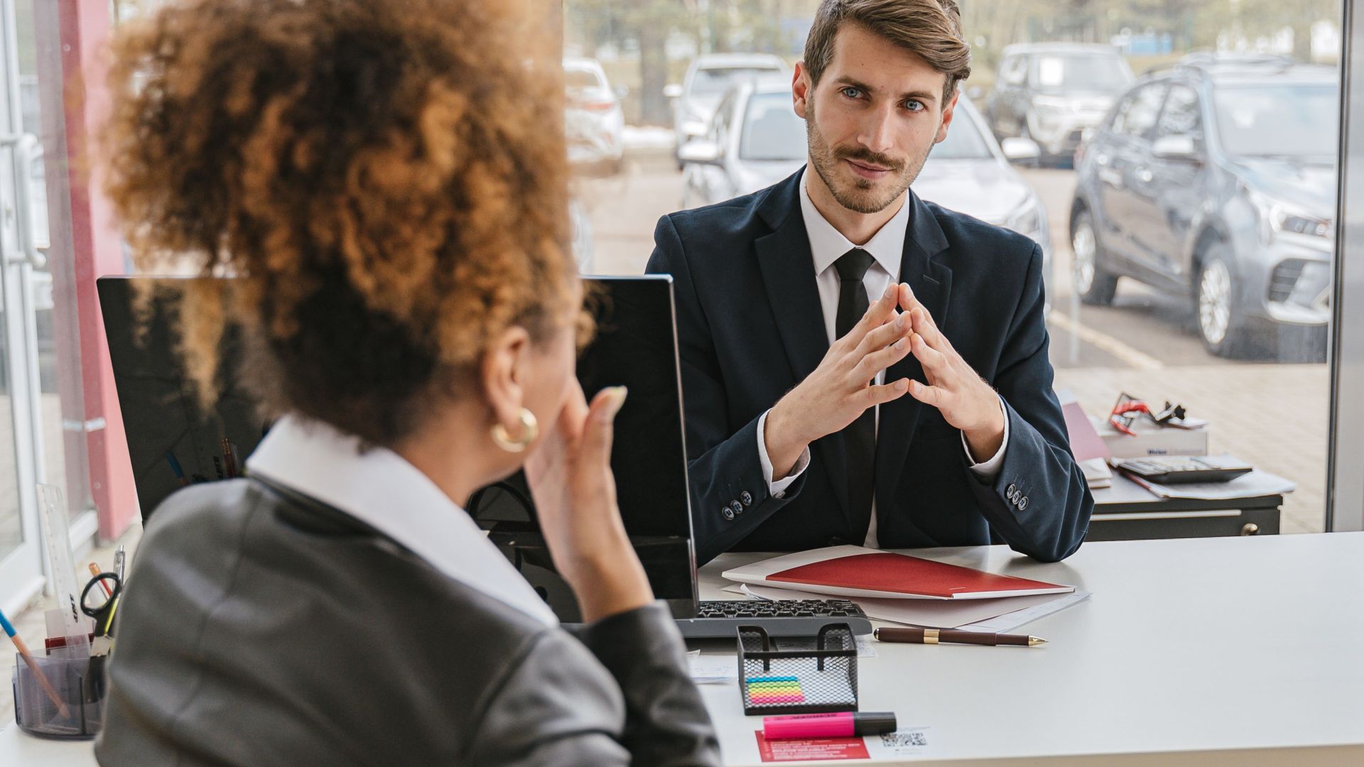 Business professionals engaged in conversation at a modern office desk, discussing ideas and strategies.