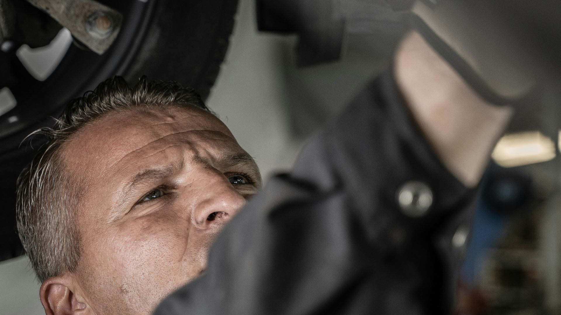 a man working on a car under a vehicle