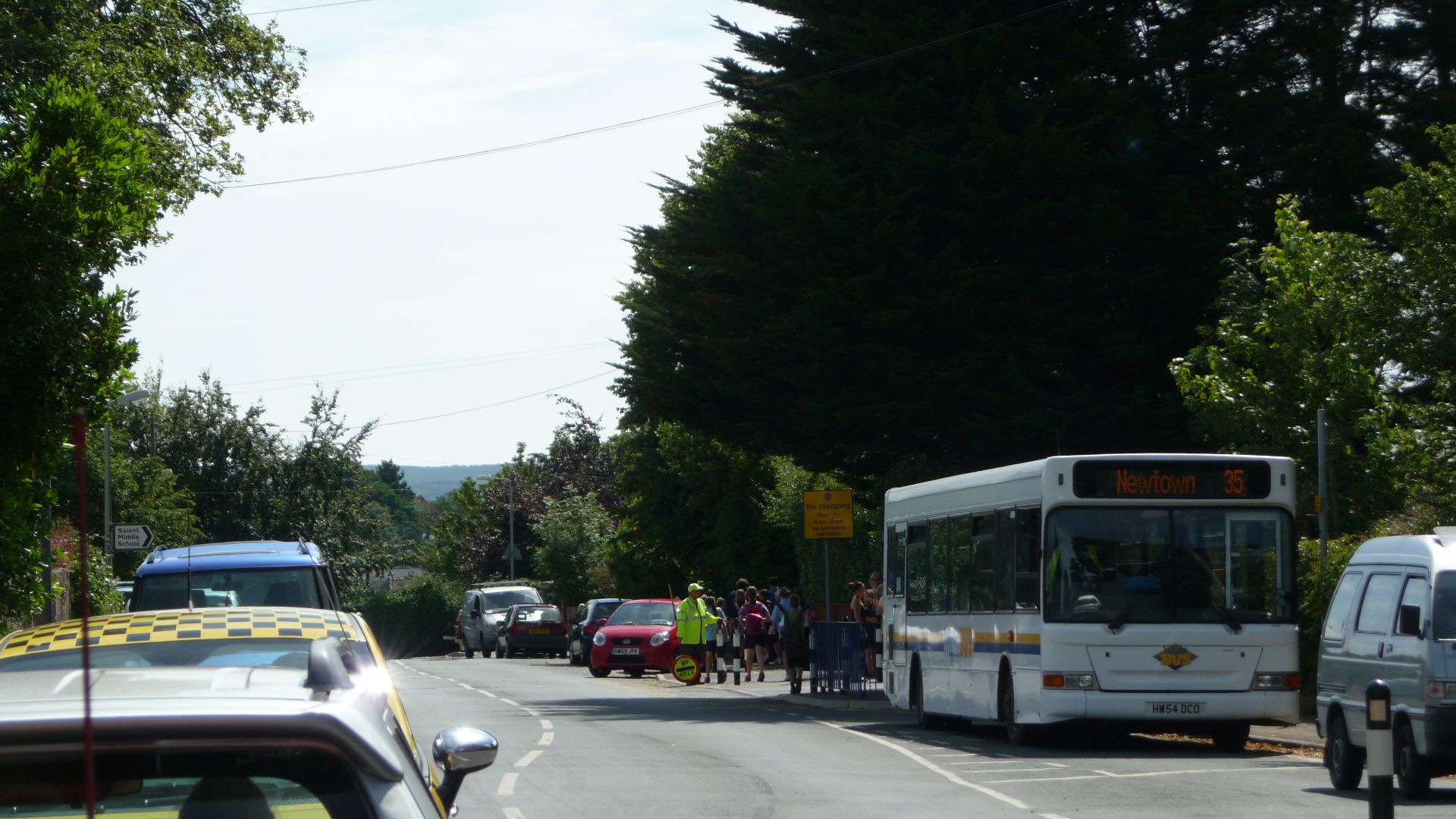 Wightbus 5804 (HW54 DCO), a Dennis Dart SLF/Plaxton Pointer 2, in Baring Road, Cowes, Isle of Wight. It is picking up school children at Solent Middle School, on route 135 to Newton via Thorness. It picks up at both Solent Middle and Gurnard Primary Schoo