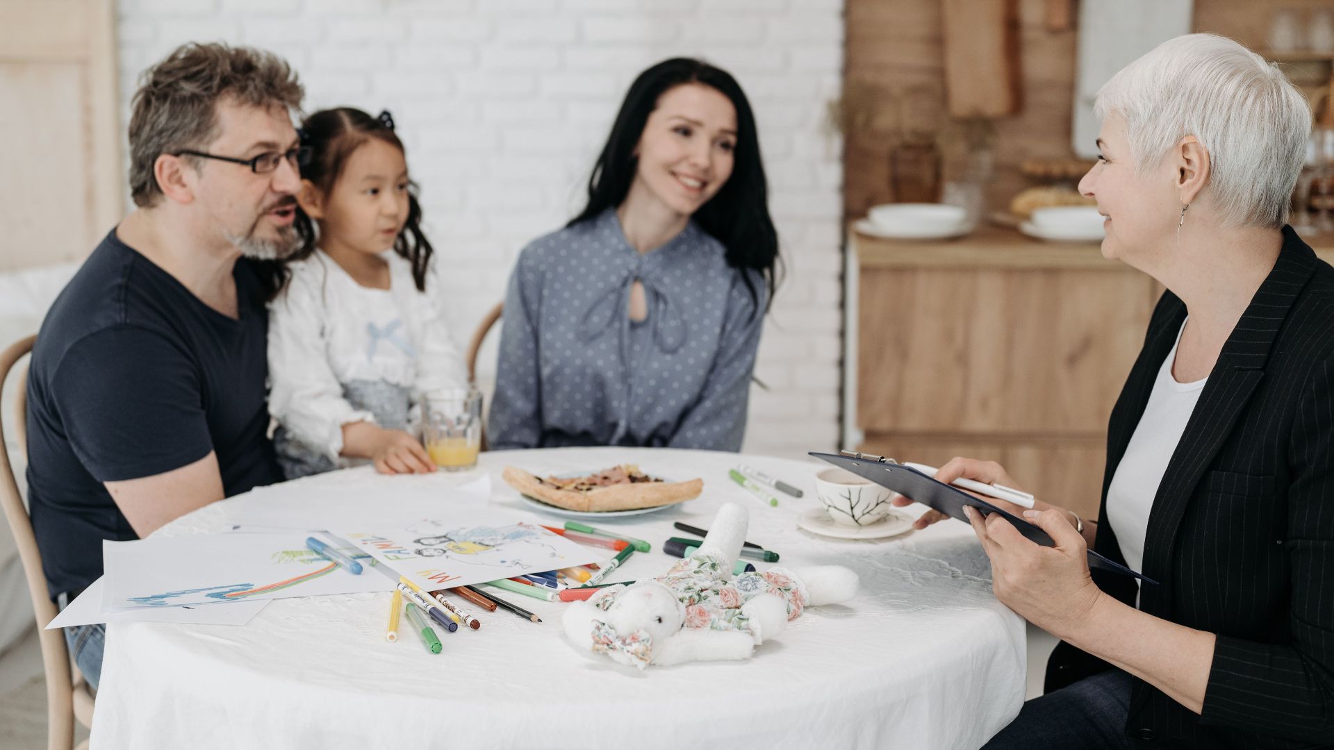 Adoptive family discussing with a social worker indoors, creating a warm, welcoming atmosphere.