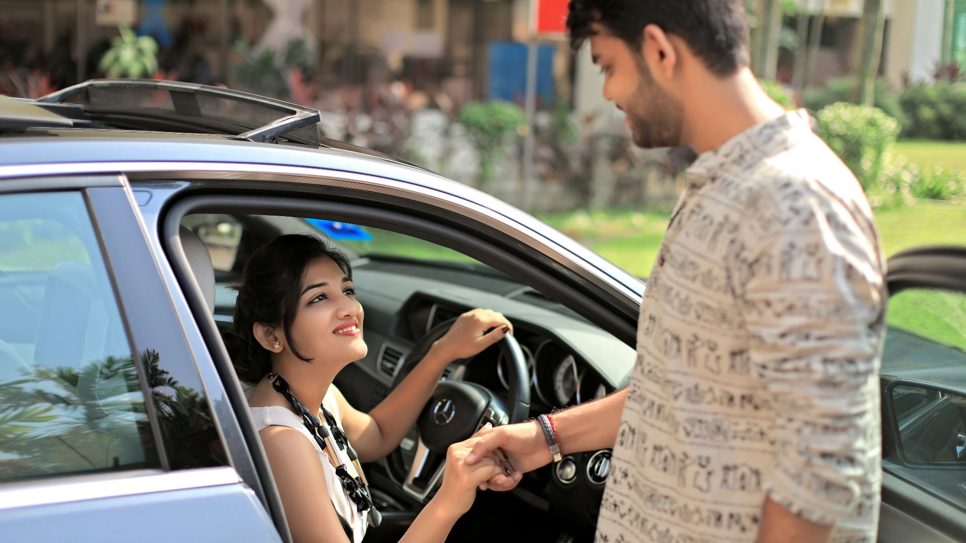 man standing while in front of woman who inside vehicle