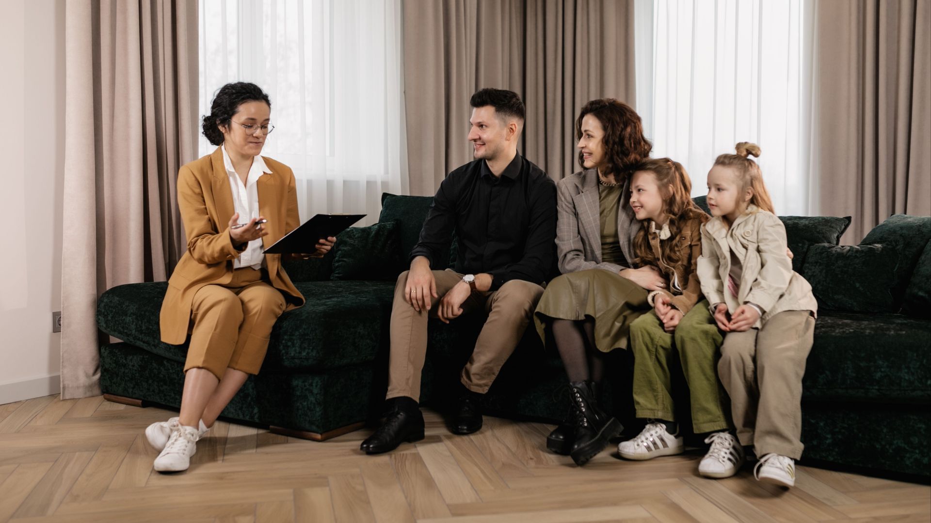 Family discussing home purchase options with real estate agent indoors.