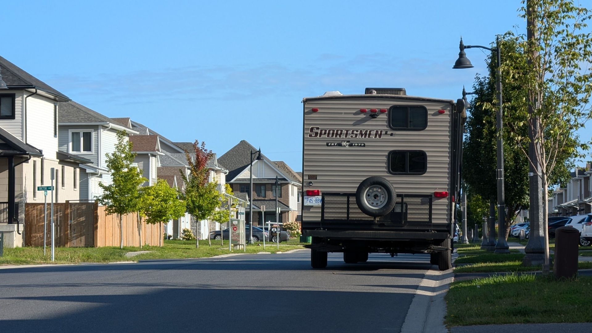 Sunny day view of a suburban street with a camper in Kingston, Ontario, Canada.