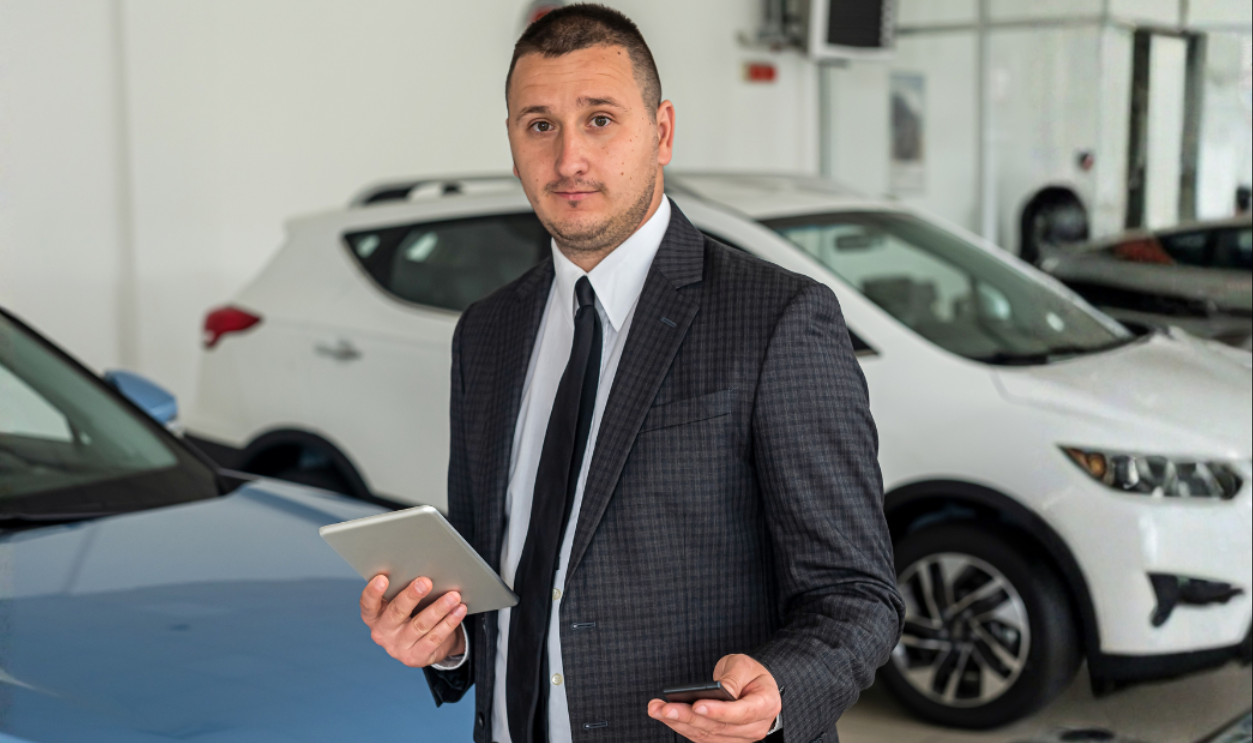 Satisfied happy young male customer choosing new car at showroom or dealership. vehicle sale concept