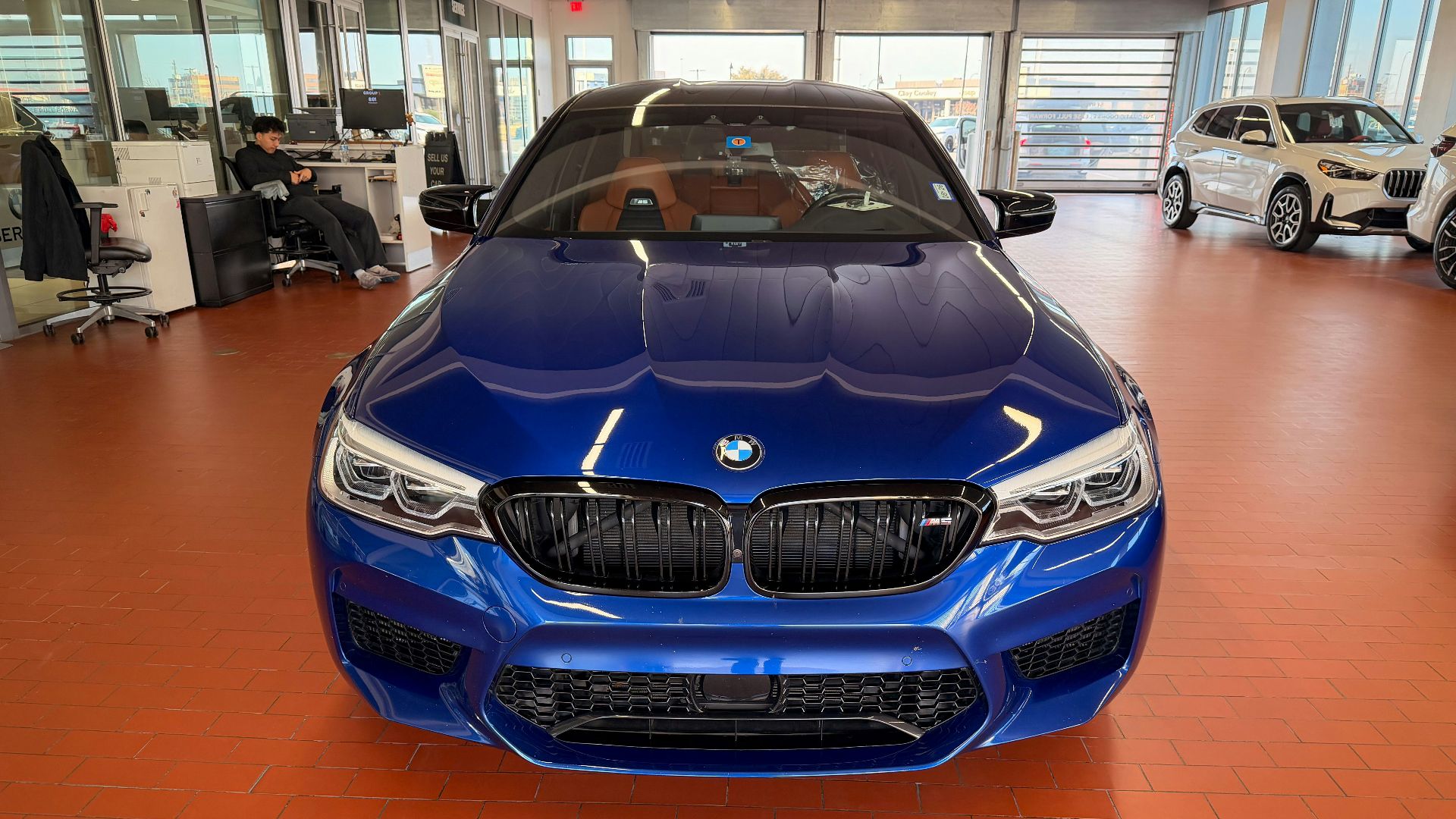A blue BMW car parked inside a modern showroom
