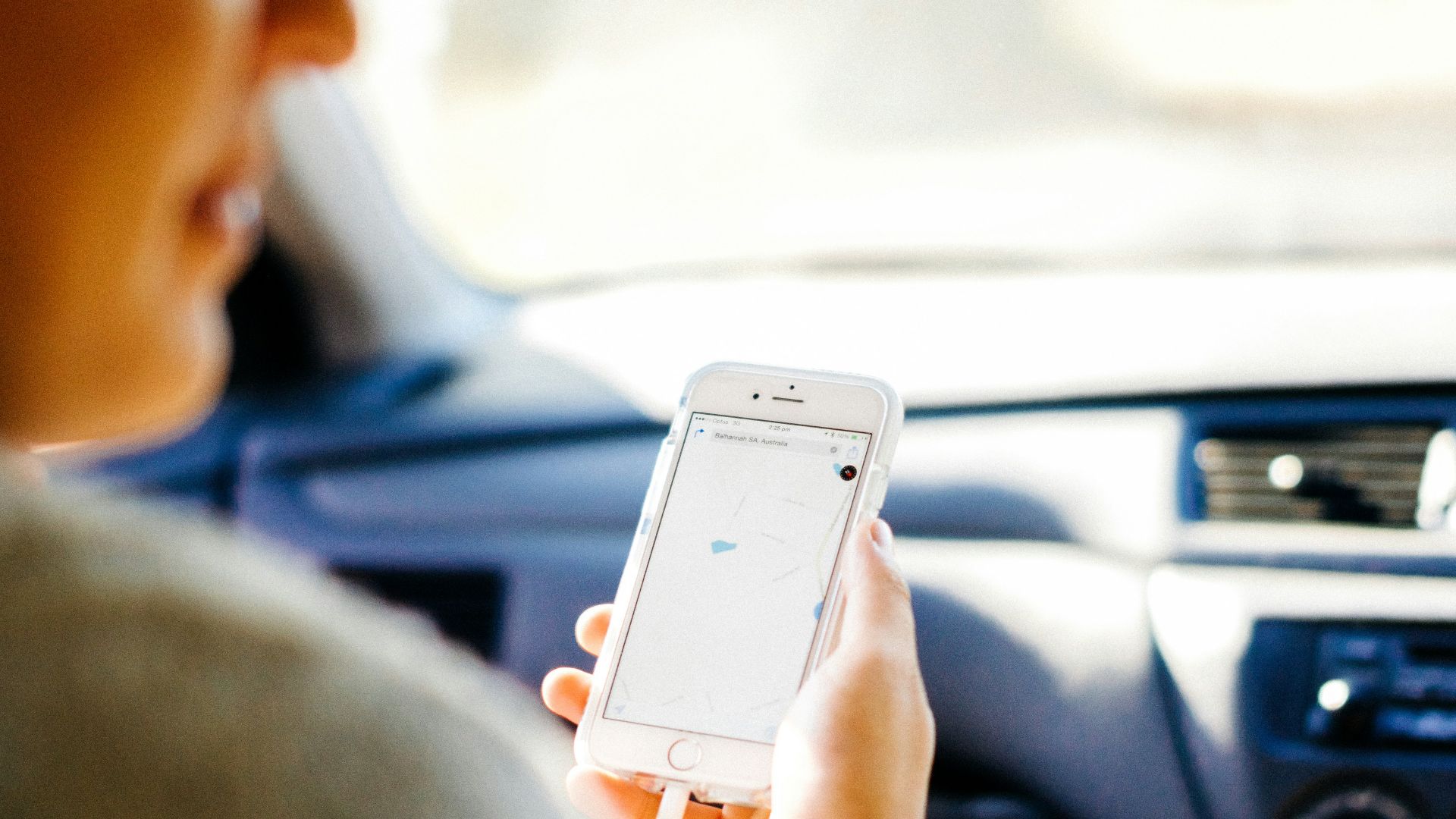 a woman holding a cell phone in a car