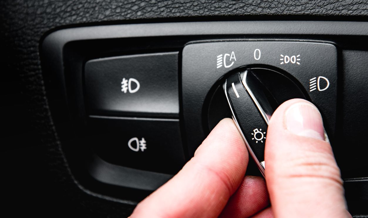 Hand turning auto light in luxury car.
