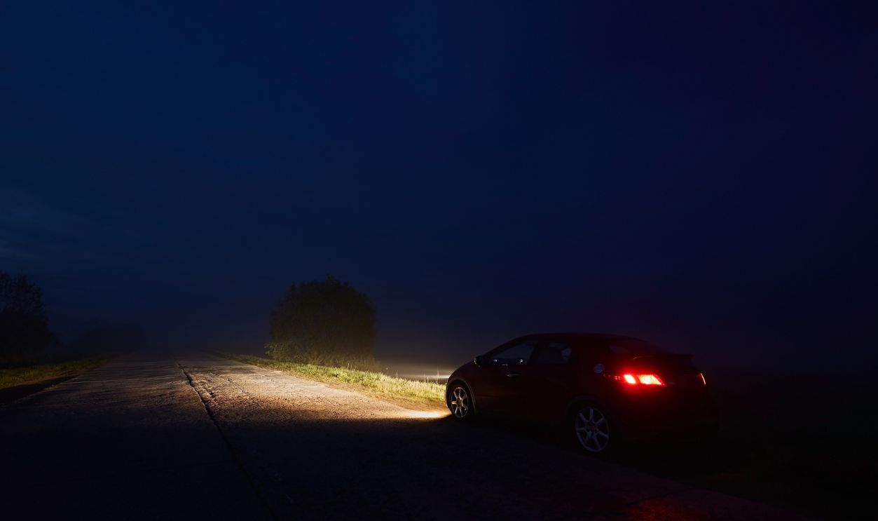 Petersburg, Russia – May 18 2021: Honda Civic car driving along a night road against the background of a dark sky, headlights on the asphalt