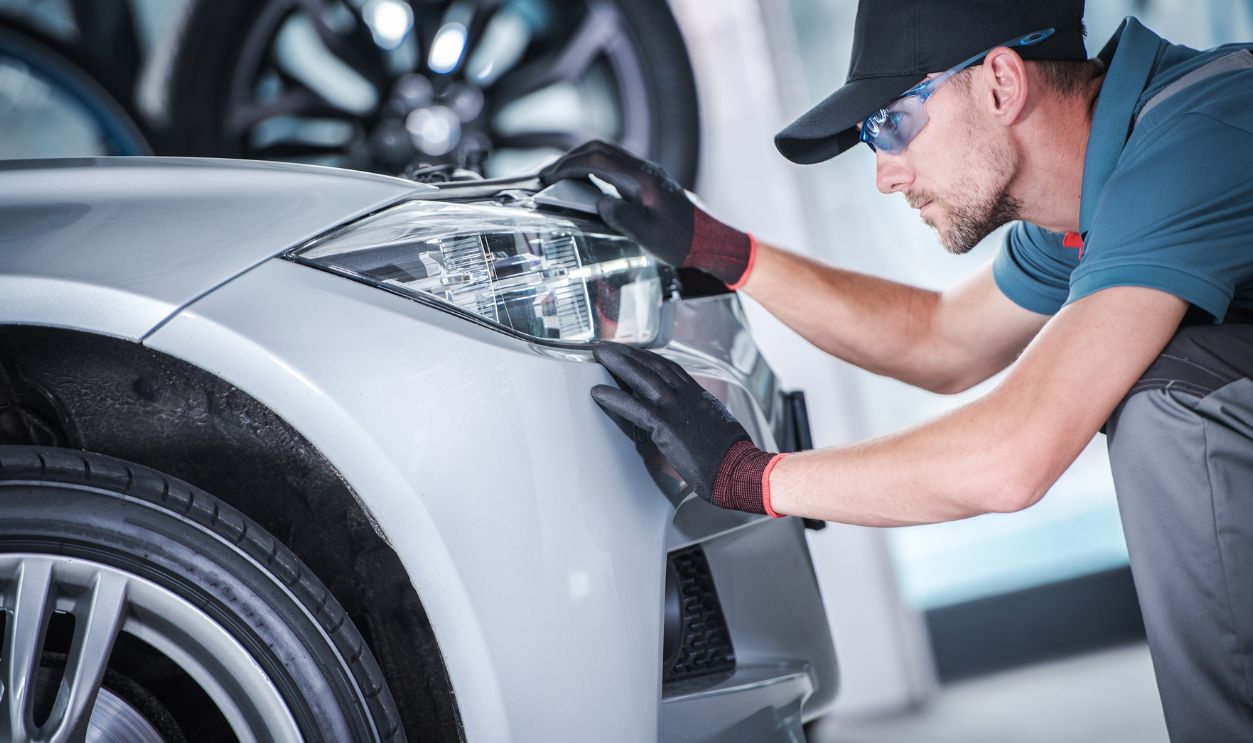 Shutterstock-1162694524, Aim and Adjust Car Headlights. Caucasian Worker in Front of the LED Vehicle Front Lamp Looking For Issues. Safety on the Road.