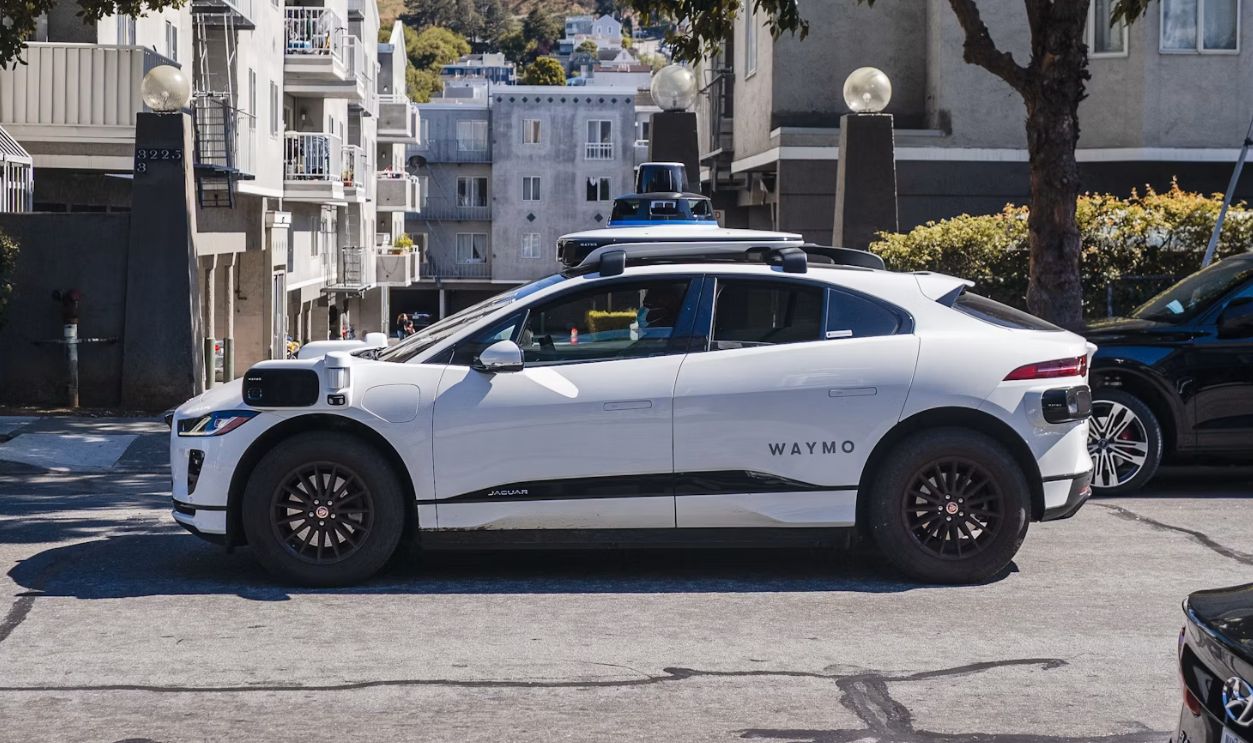 A white self-driving car on a city street