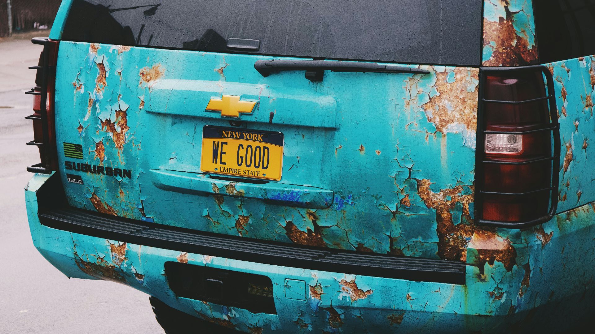 the back of a blue truck with rust on it