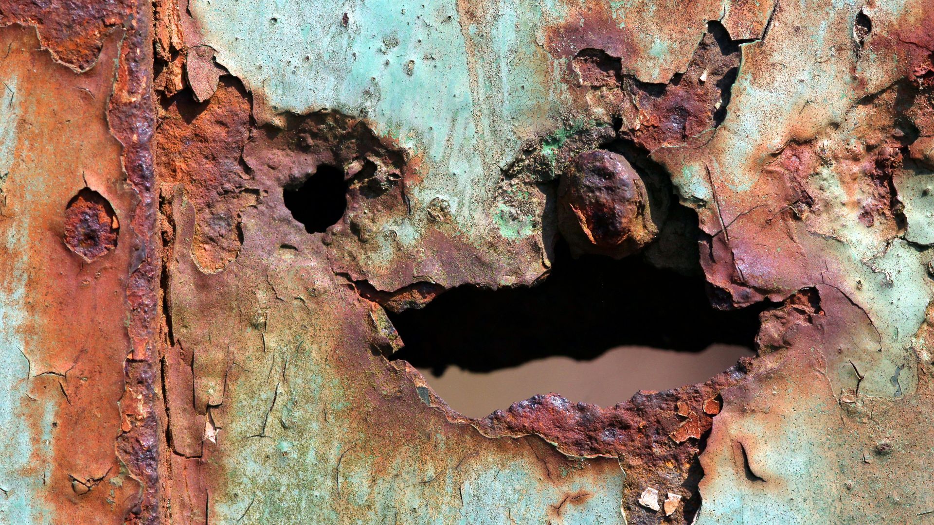 a rusted metal surface with a hole in the middle