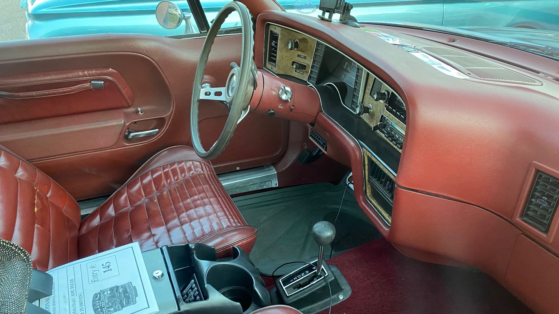 1976 AMC Pacer coupe, an innovative compact-sized car built by American Motors Corporation (AMC). This is a D/L model finished in Autumn Red Metallic (paint code H8) and has a matching berry interior with bucket seats.
Photographs were taken during the Ju