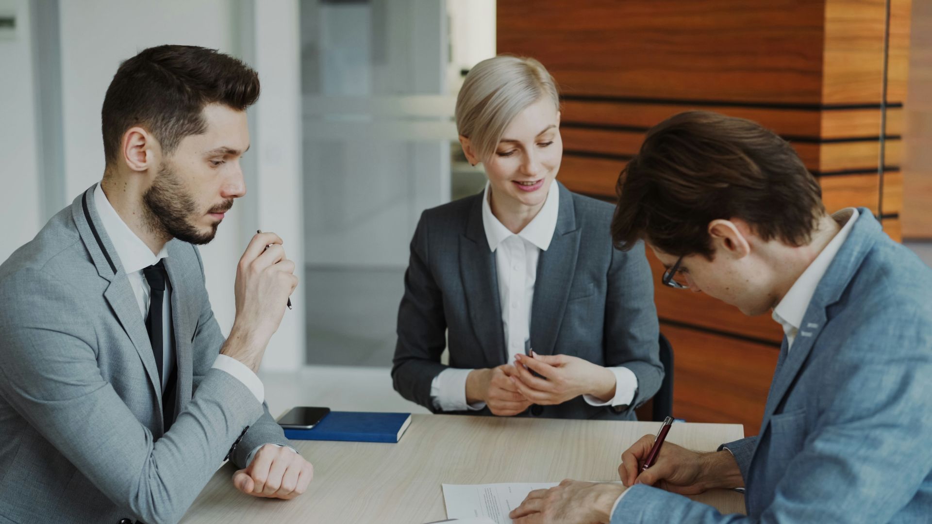 Business people signing a contract at a table