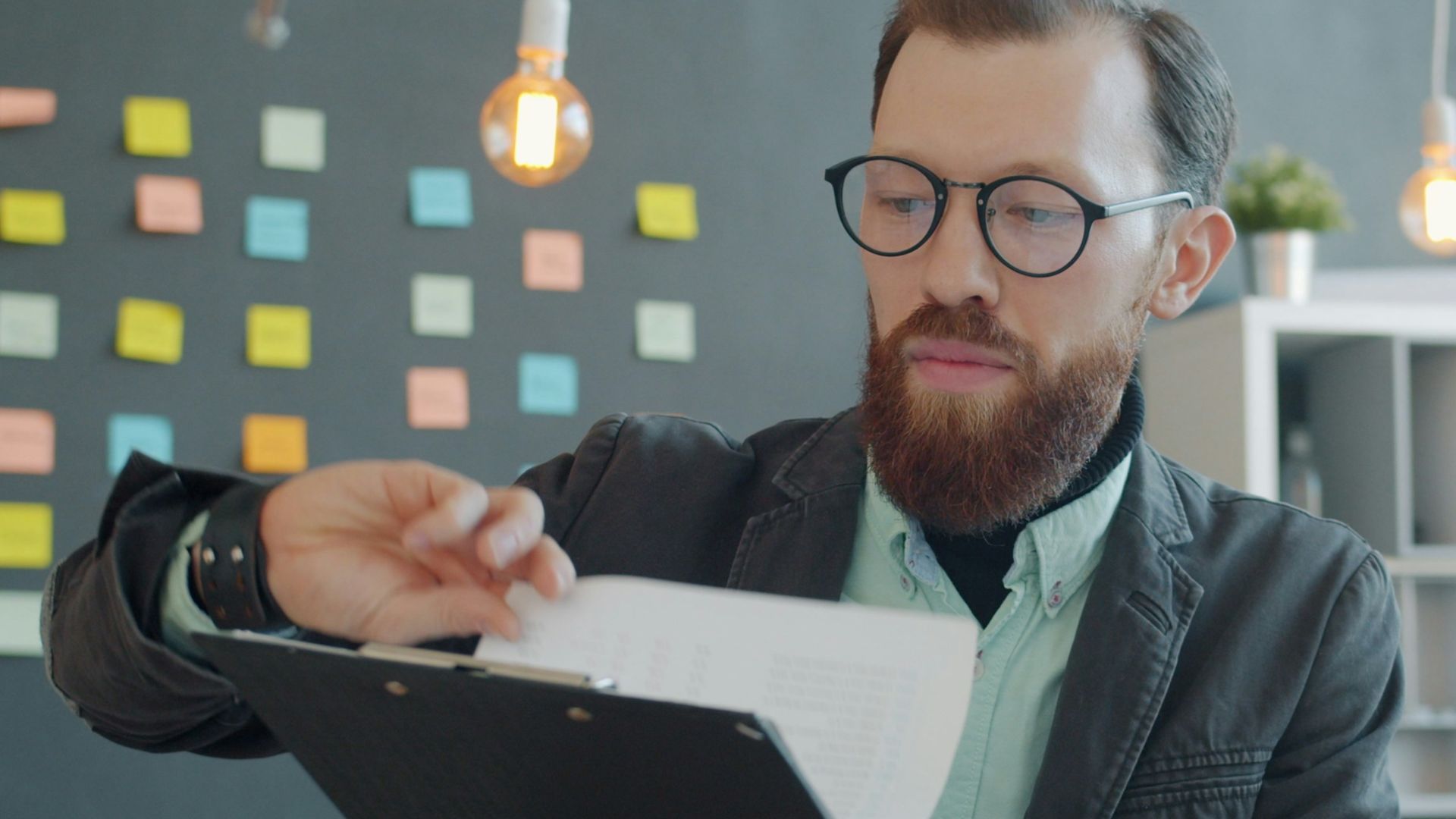 Man in glasses reviewing documents at desk