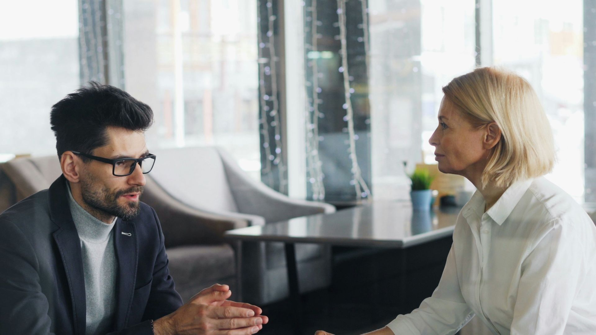 a man and a woman sitting at a table talking